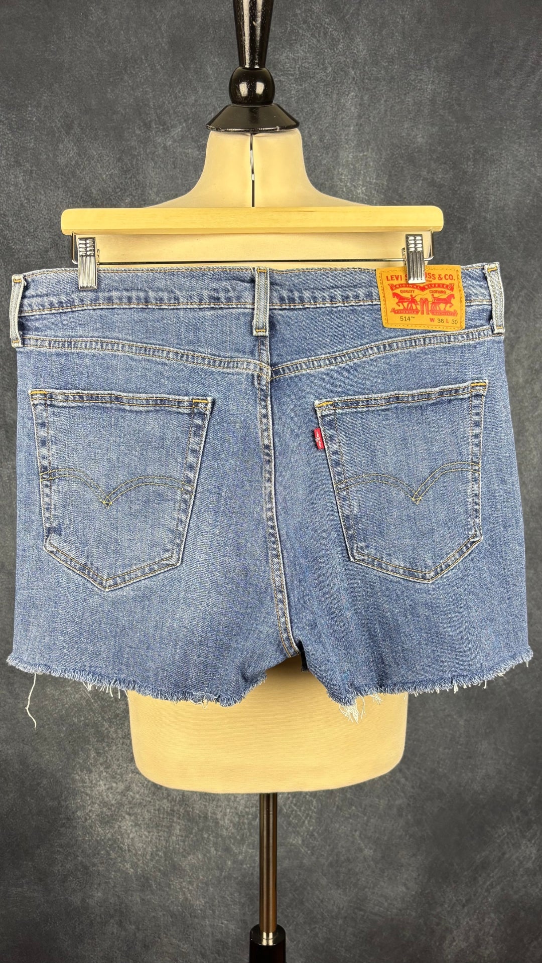 Short en jeans court à franges à l'ourlet Levi's modèle 514, taille 36. Vue de dos, sur cintre.
