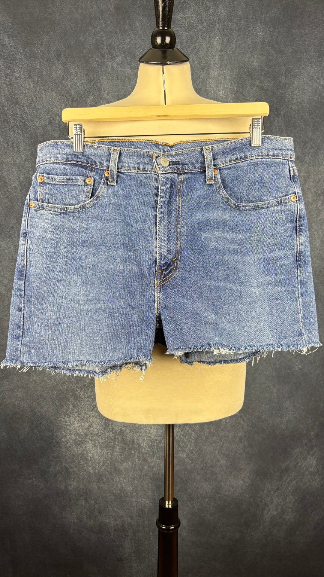 Short en jeans court à franges à l'ourlet Levi's modèle 514, taille 36. Vue de face, sur cintre.