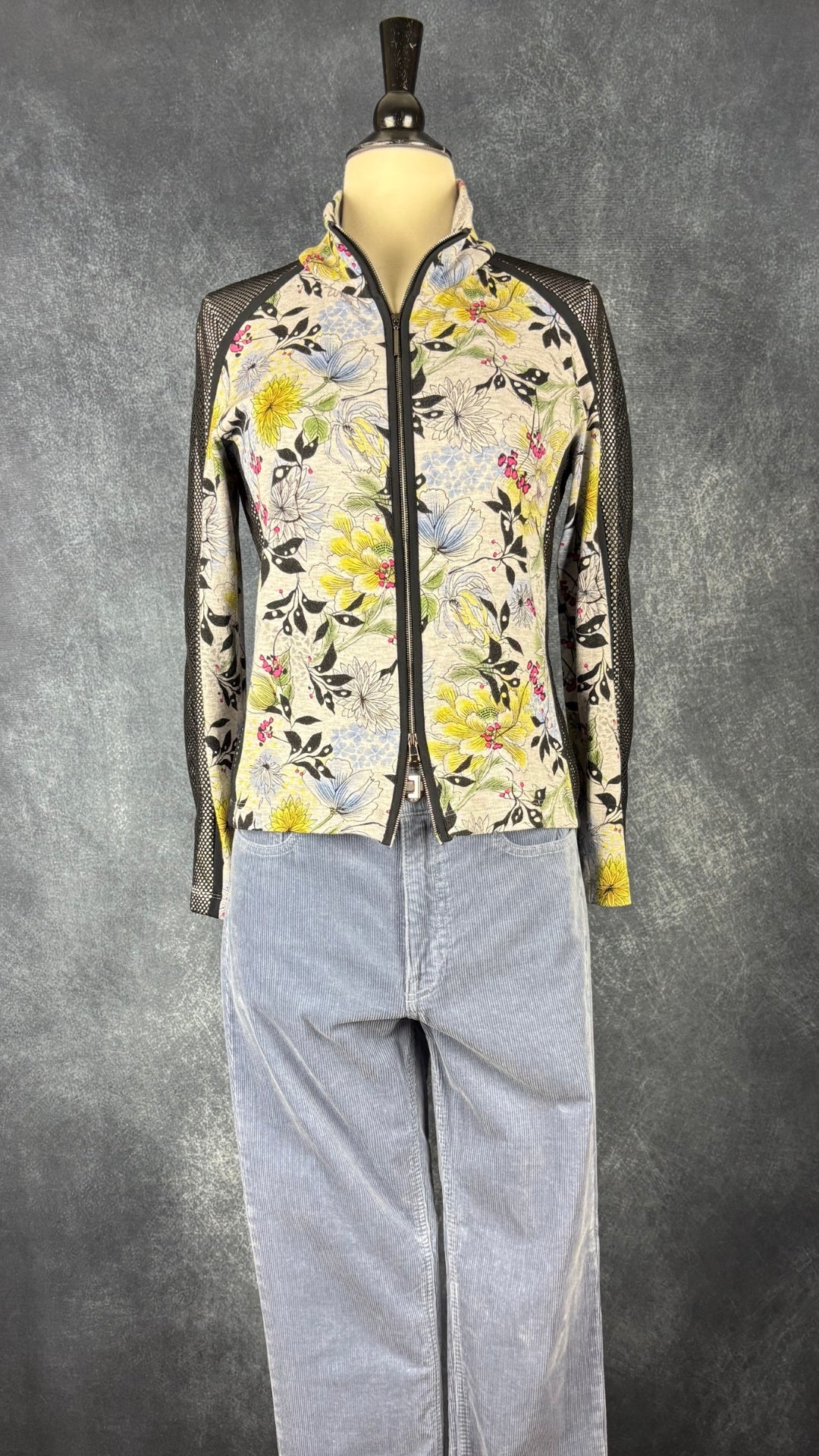 Veste florale en jersey et insertions de maille noire Marc Cain, taille N3 (s/m). Vue de l'agencement avec le pantalon en velours côtelé bleu doux Club Monaco.