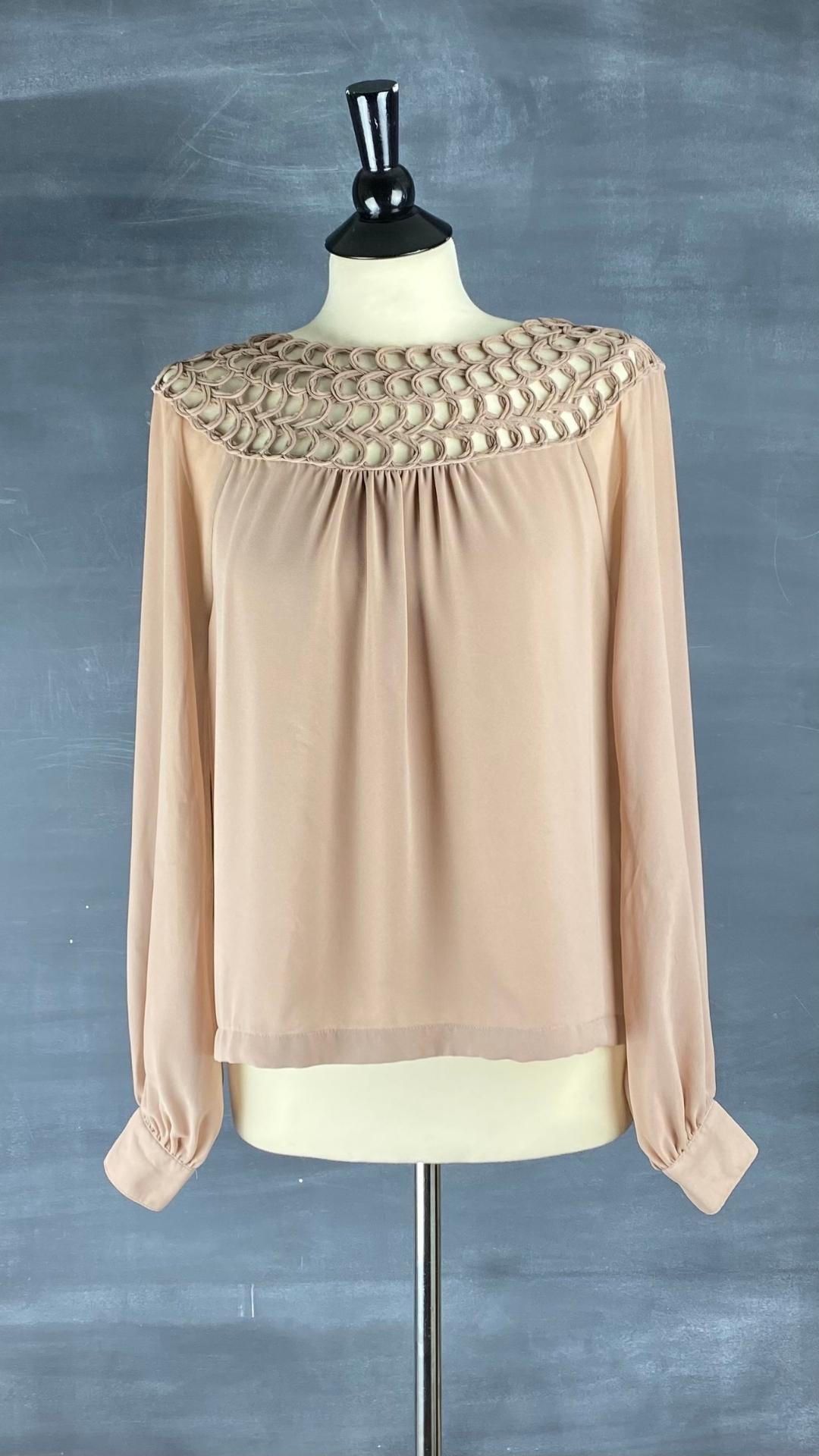 Cette splendide blouse possède un col détaillé ajouré spectaculaire, vue de face