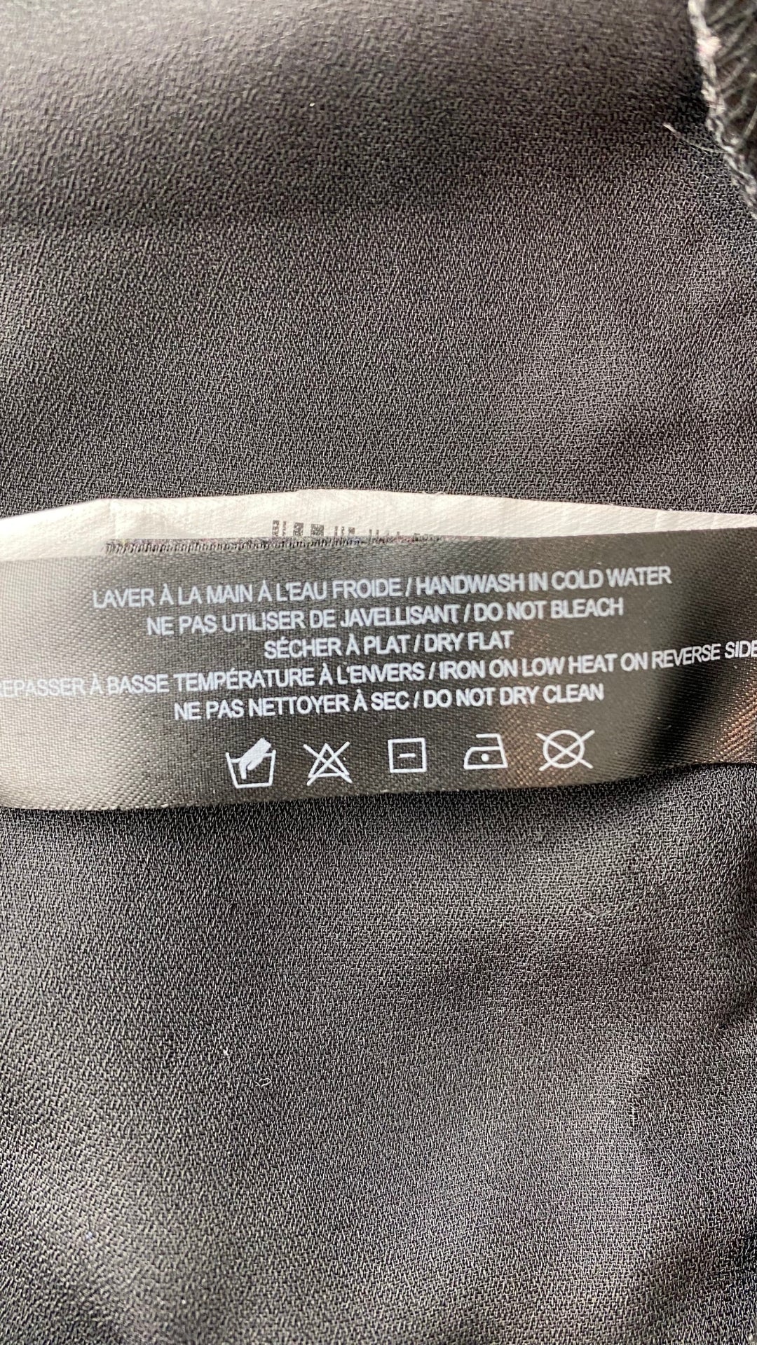 Camisole noire Rudsak double épaisseur avec filet. Vue de l'étiquette d'entretien.