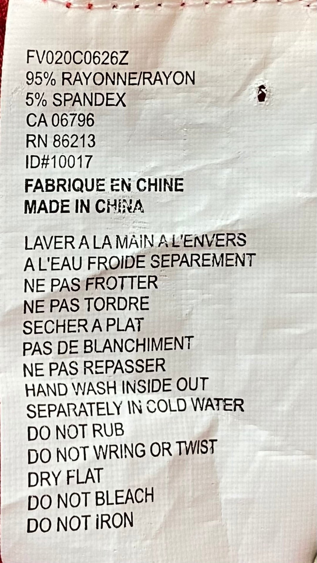 Un joli t-shirt rouge à paillettes pour égayer tes looks festifs. Vue de l'étiquette de composition et entretien.