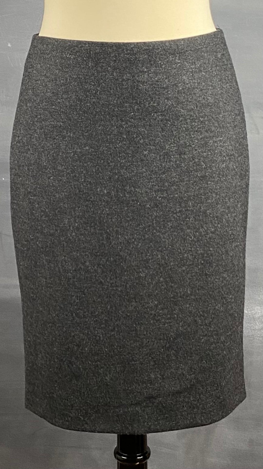 Jupe crayon en lainage gris faite au Canada. Zip au dos pour la fente d'aisance. Vue de face.