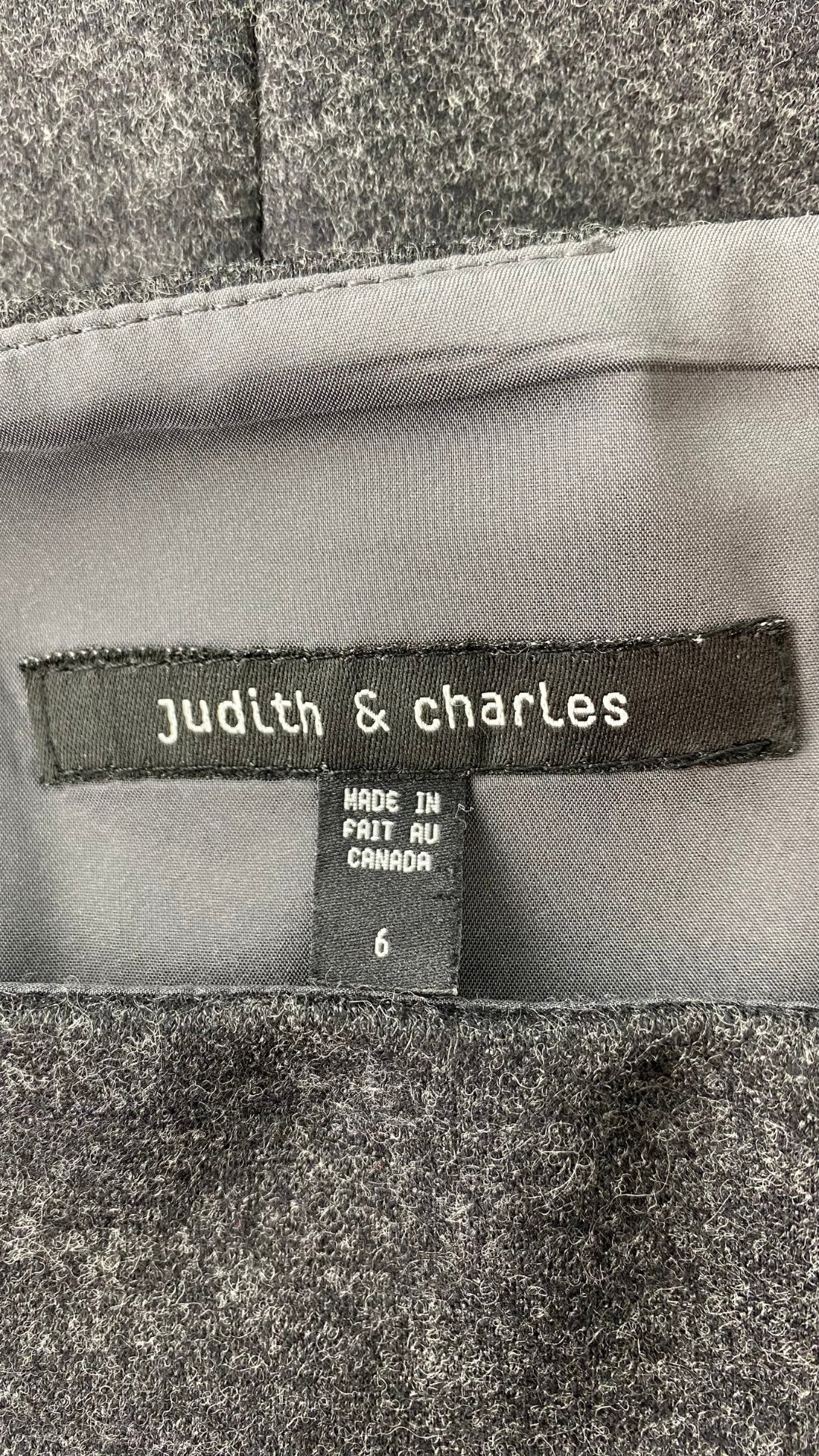 Jupe crayon en lainage gris faite au Canada. Zip au dos pour la fente d'aisance. Vue de l'étiquette de marque et taille.