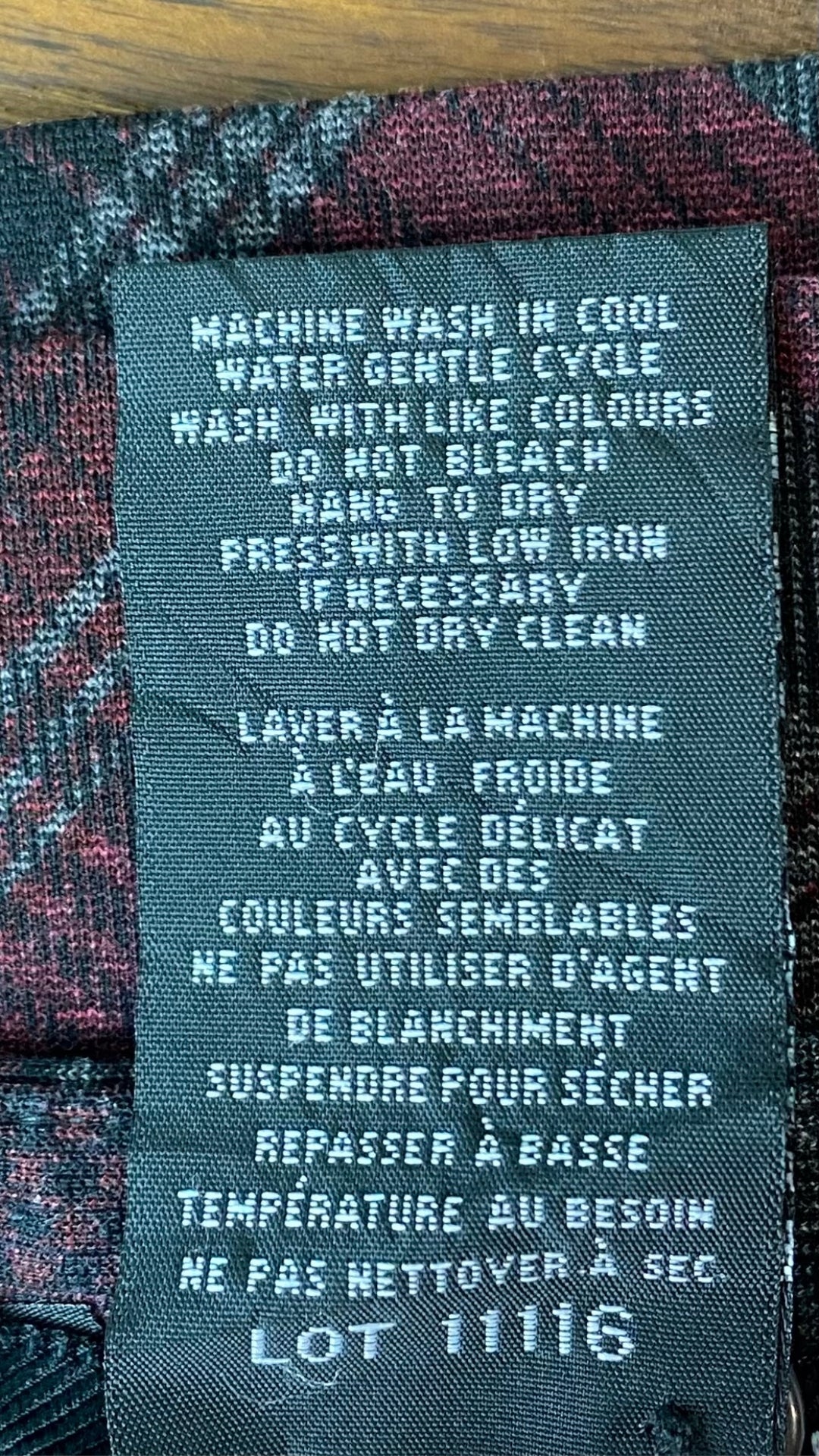 Jupe ligne A à carreaux gris et bourgogne. Classique et facile à agencer. Vue de l'étiquette d'entretien.