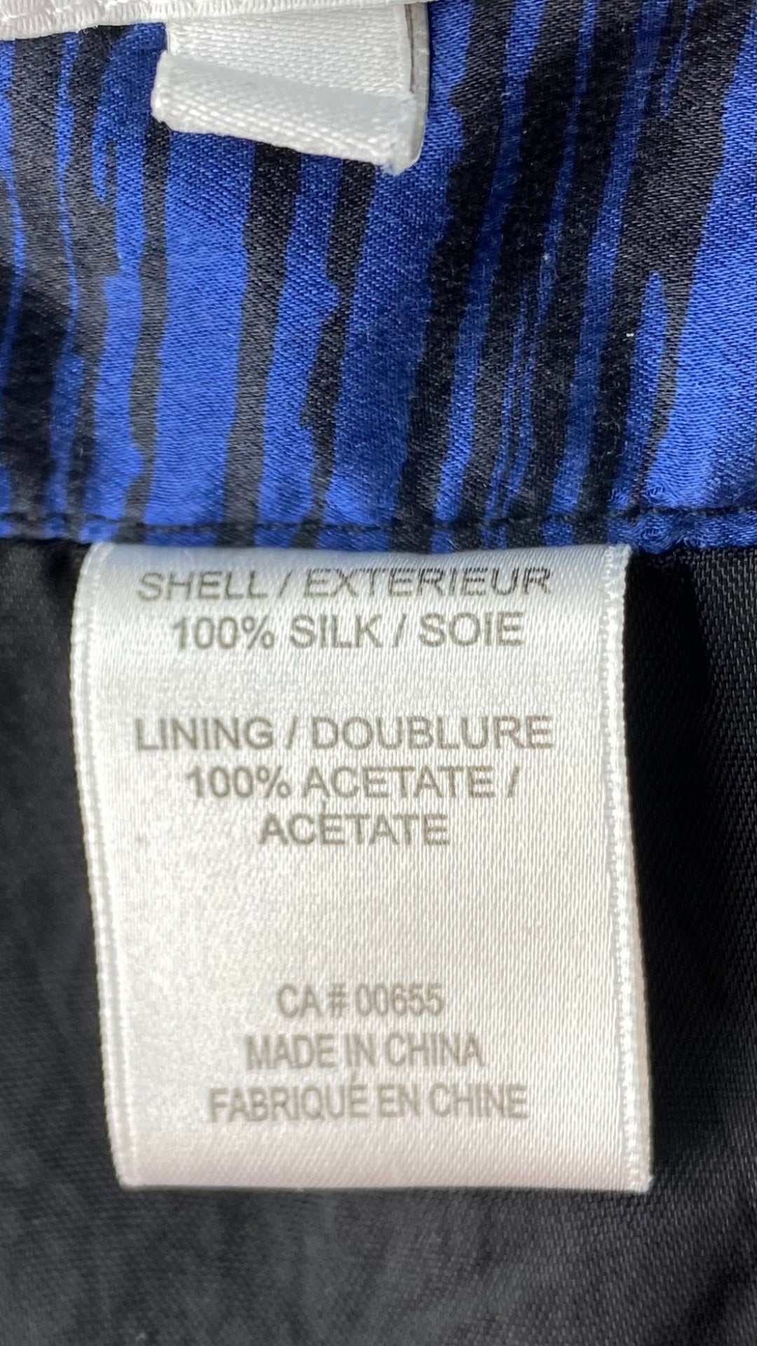 Jupe en soie plissée à motifs abstraits bleu royal et noir. Vue de l'étiquette de composition.