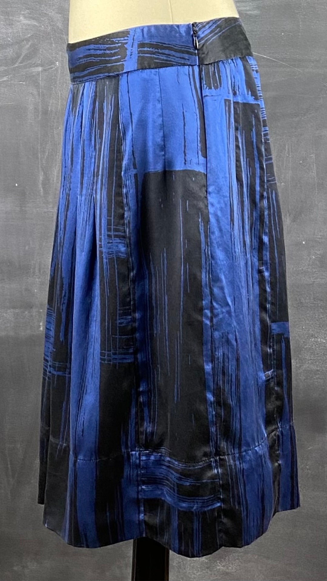Jupe en soie plissée à motifs abstraits bleu royal et noir. Vue de côté.