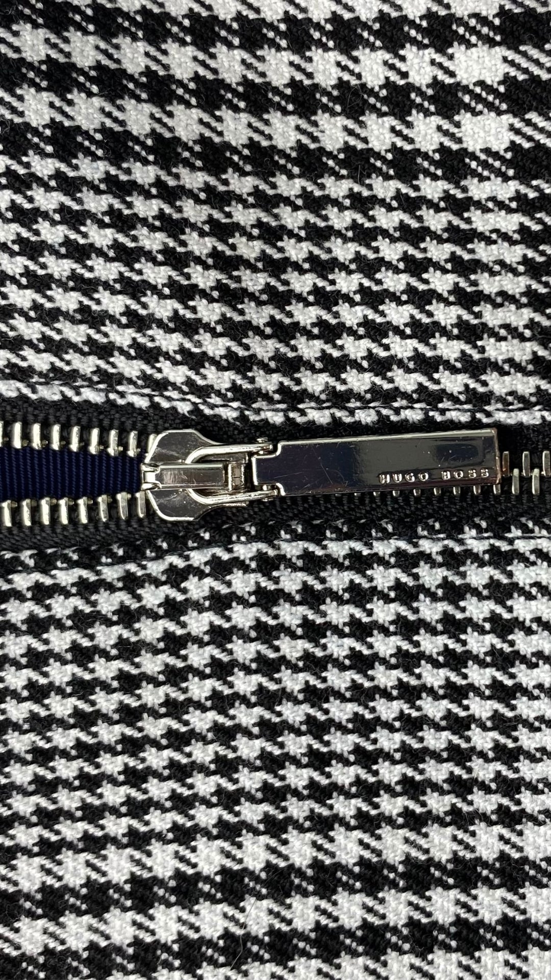Robe à carreaux pied de poule Boss. Parfaitement magnifique avec sa belle coupe, son tissu de qualité et sa petite fente à l'avant de la jupe. Vue de la fermeture éclair de près.