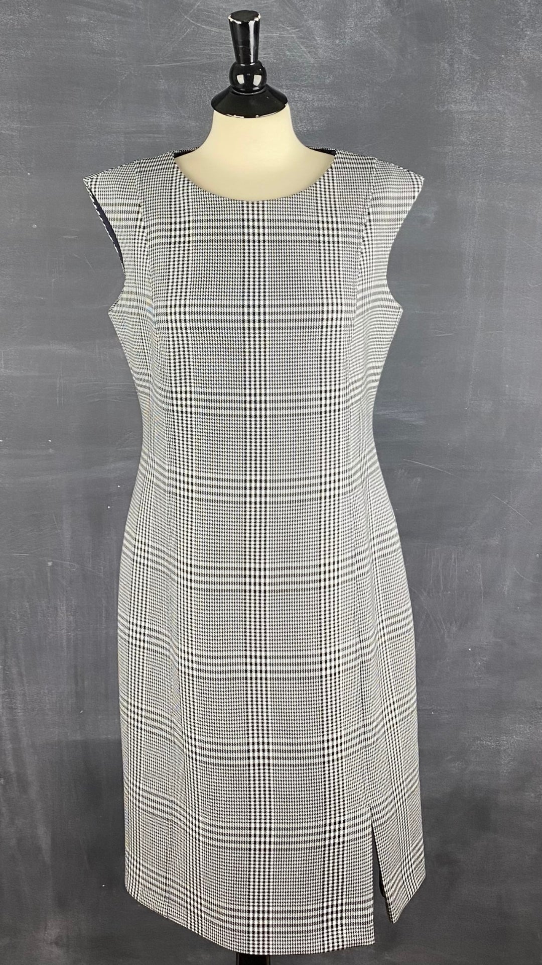 Robe à carreaux pied de poule Boss. Parfaitement magnifique avec sa belle coupe, son tissu de qualité et sa petite fente à l'avant de la jupe. Vue de face.