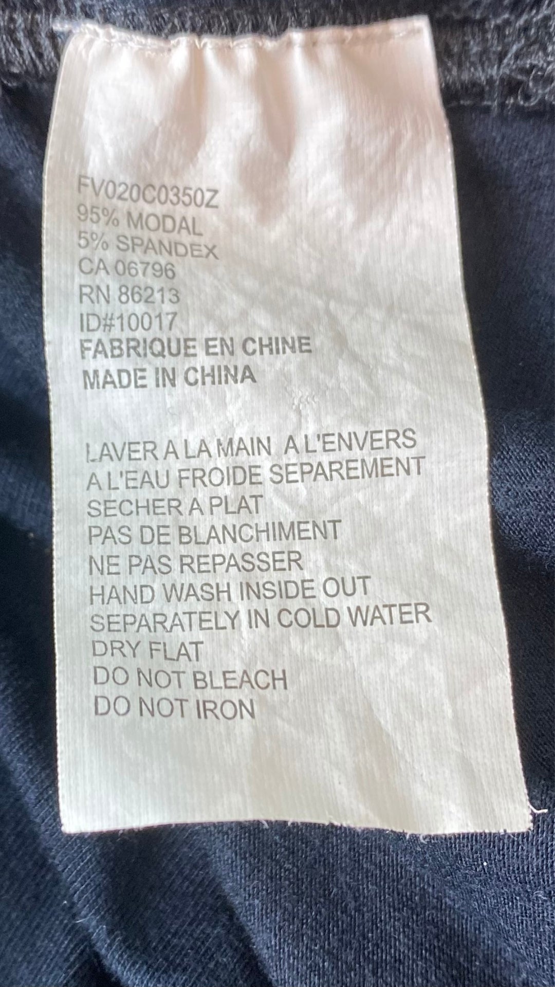 Robe ajustée et froncée sur les côtés avec un col baveux et des manches ornées de paillettes. Vue de l'étiquette de composition.