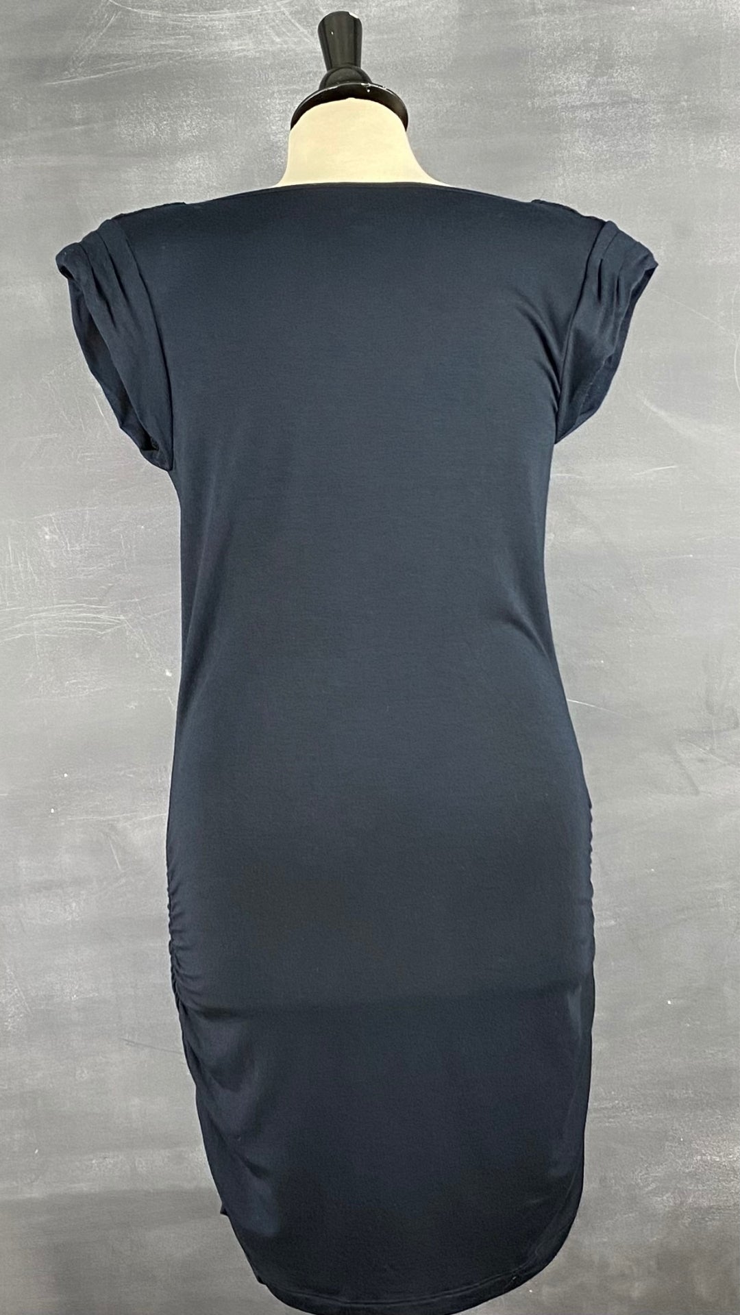 Robe ajustée et froncée sur les côtés avec un col baveux et des manches ornées de paillettes. Vue de dos.