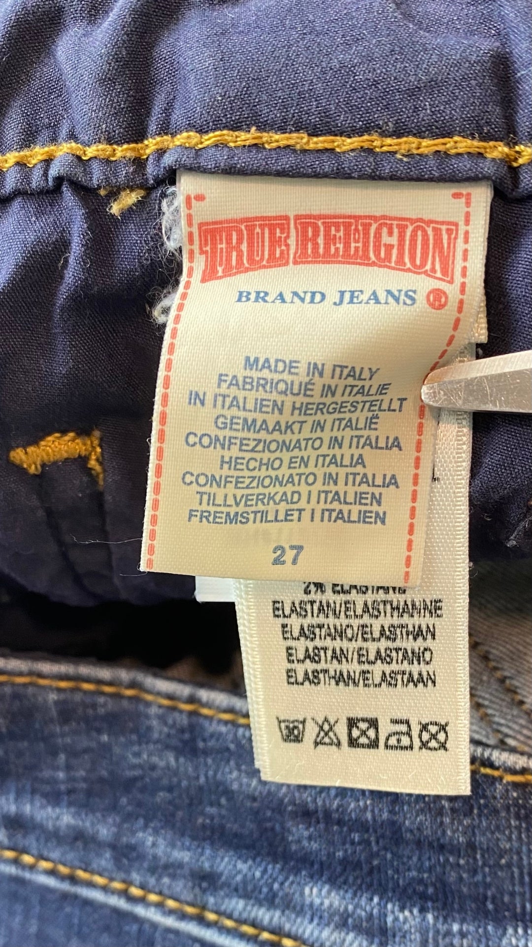 Jeans foncé à jambe étroite, True Religion, taille 27. Vue de l'étiquette de marque et taille.