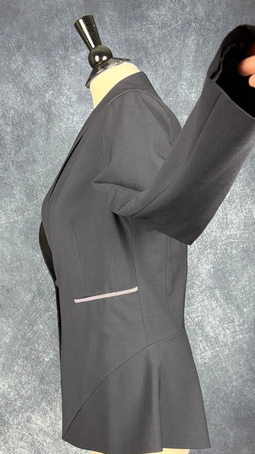Blazer marine très foncé avec insertion de baguettes scintillantes à la taille Brunello Cucinelli, taille estimée à s/m. Vue de côté, manche relevée.
