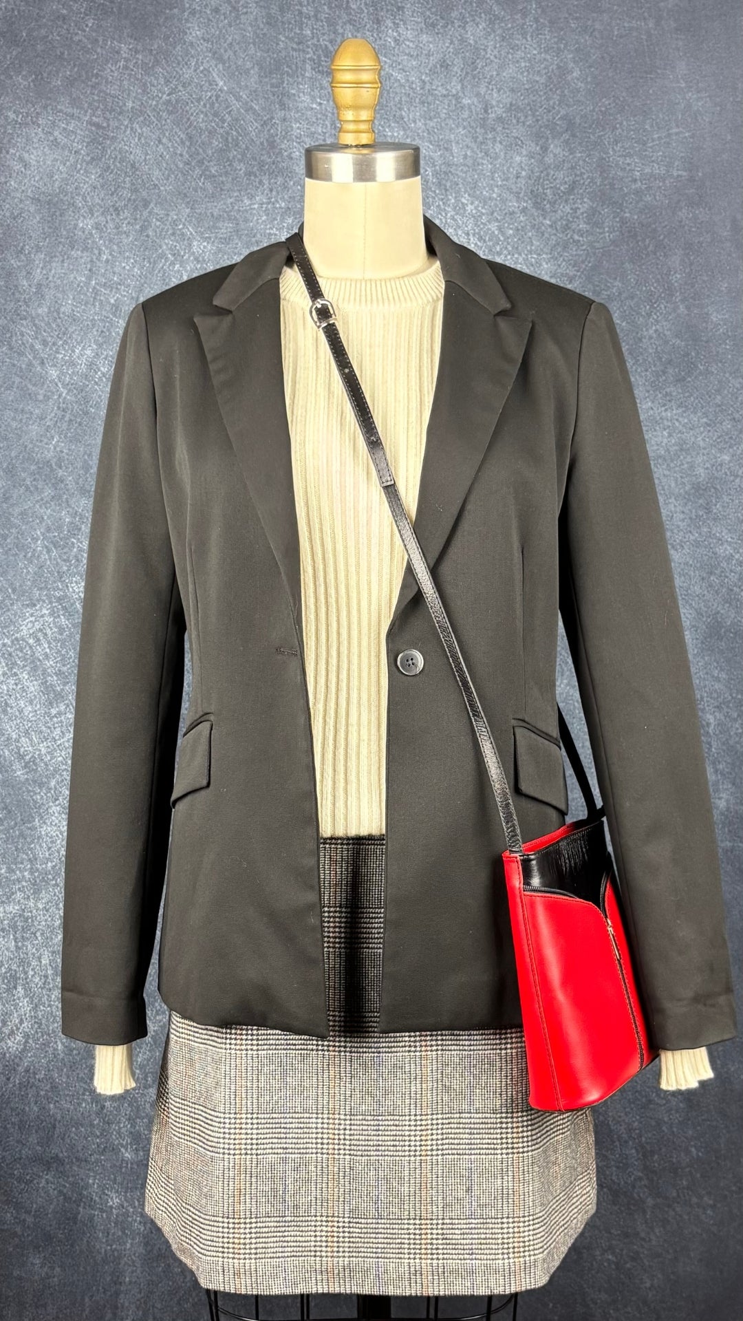 Blazer noir ajusté lavable Tristan, taille 6. Vue de l'agencement avec la jupe à carreaux Wilfred, le chandail en cachemire crème Club Monaco et le sac à main en cuir rouge et noir.