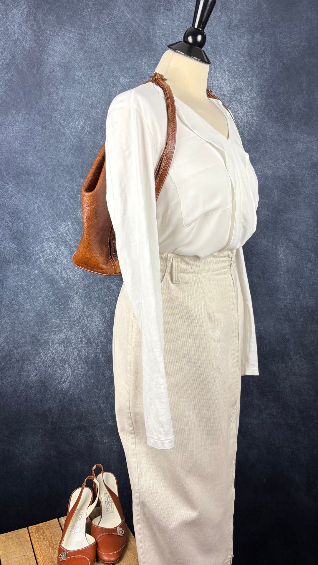 Blouse crème bi-matière à volant central Olsen, taille medium. Vue de l'agencement avec le sac Matteo Mio, la jupe Harly Jae et les escarpins à bride Salvatore Ferragamo.