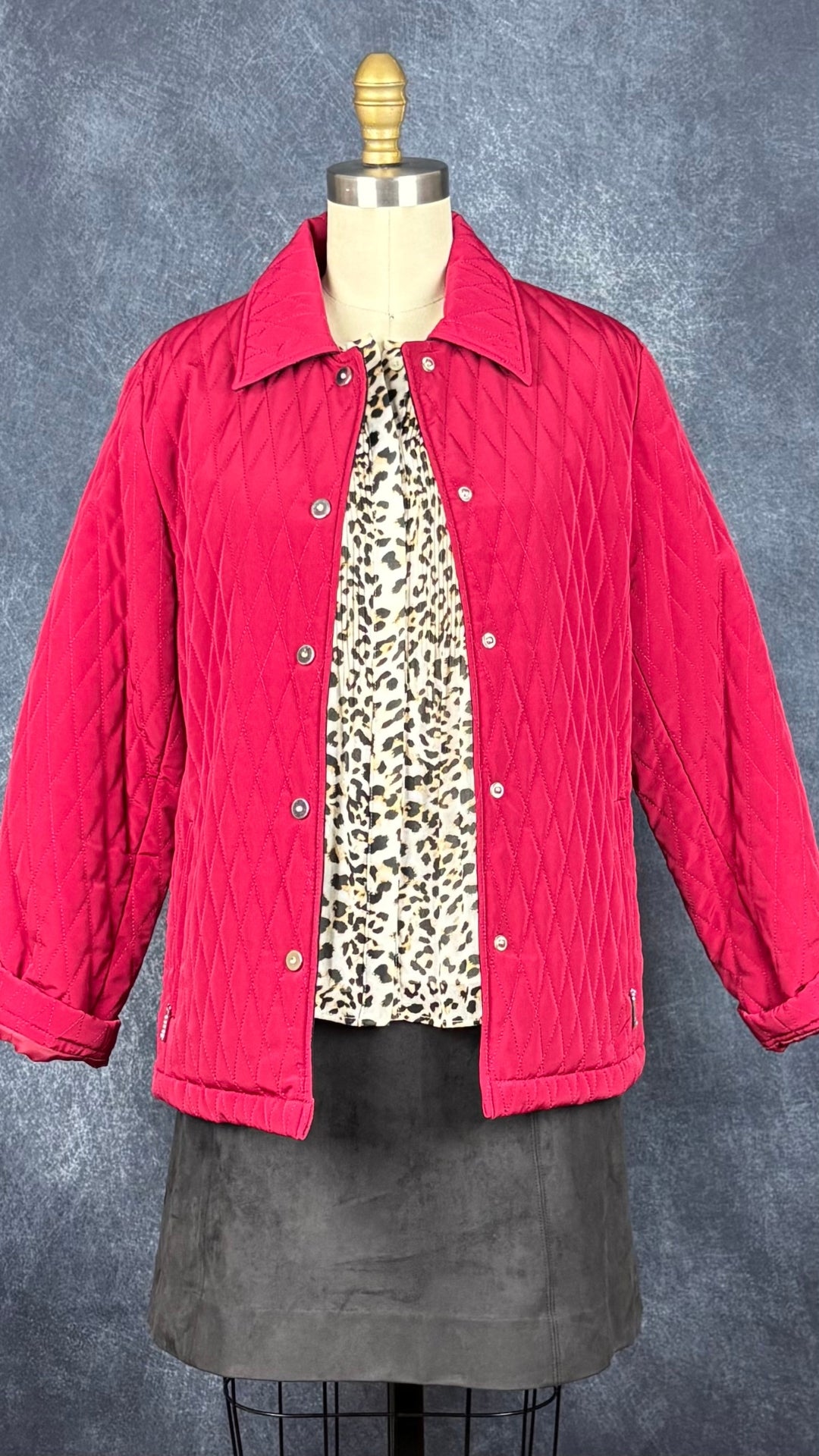 Blouse plissée à motif léopard Banana Republic, taille small. Vue de l'agencement avec le manteau matelassé rouge et la jupe suédée Babaton.