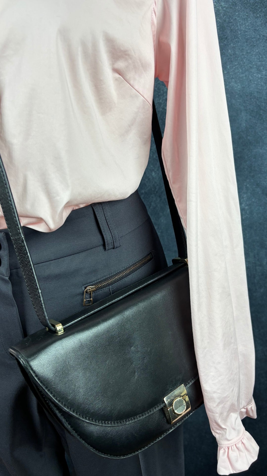 Blouse rose doux avec petits frisons au bas des manches Mos Mosh, taille large. Vue de l'agencement avec le sac noir demi-lune Flattered et le pantalon Marc Aurel (de près).
