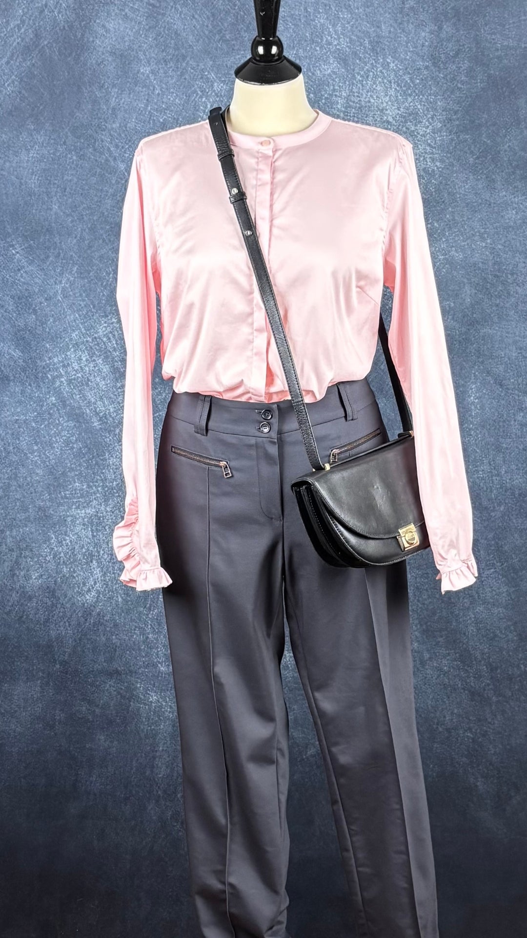 Blouse rose doux avec petits frisons au bas des manches Mos Mosh, taille large. Vue de l'agencement avec le pantalon bleu-gris Marc Aurel et le sac à main noir en demi-lune Flattered.