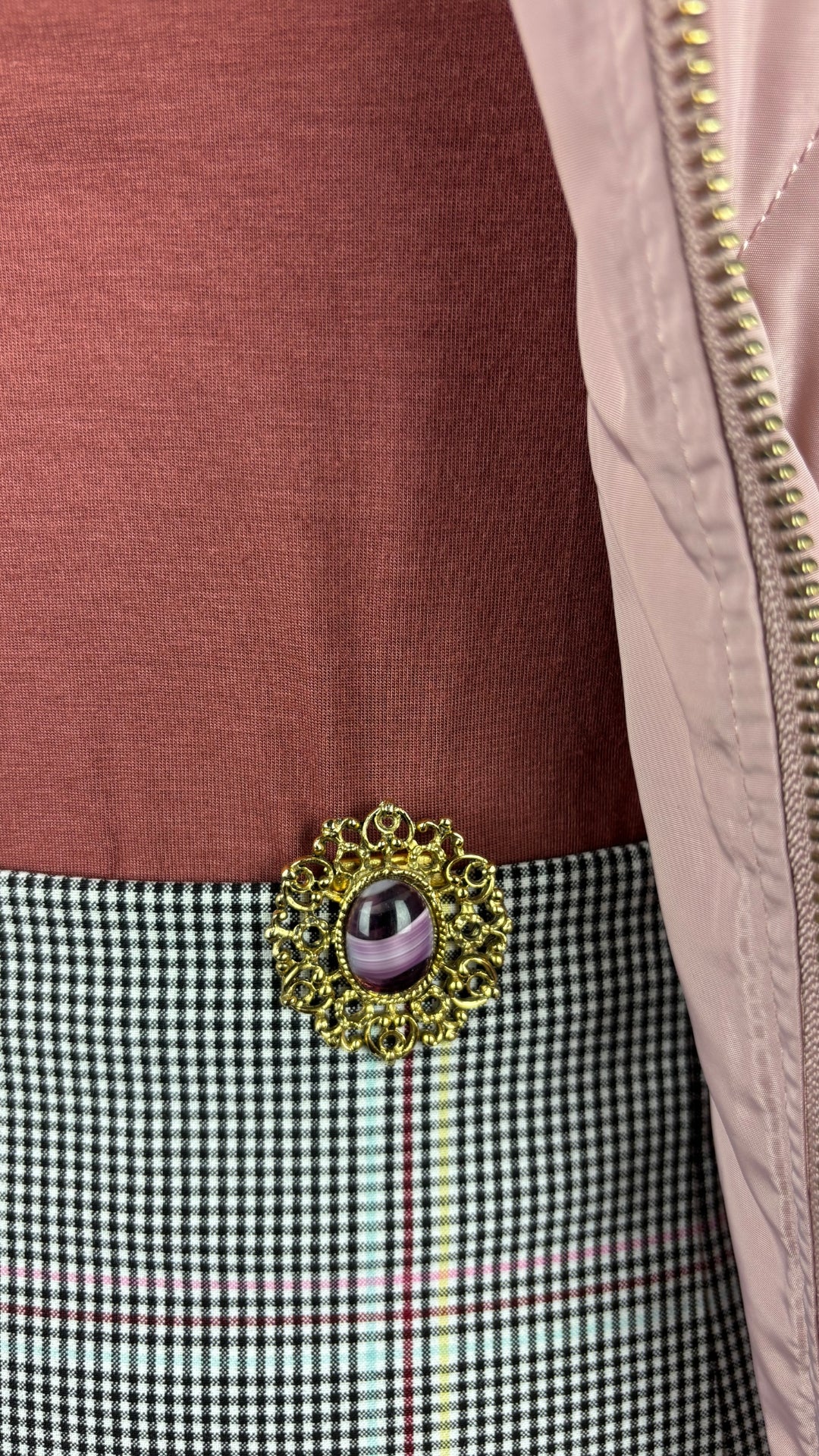 Camisole en jersey doux et extensible rose rouille Sarah Pacini, taille estimée à small/medium. Vue de près de l'agencement avec la broche vintage, la jupe à carreaux et la veste matelassée vintage.