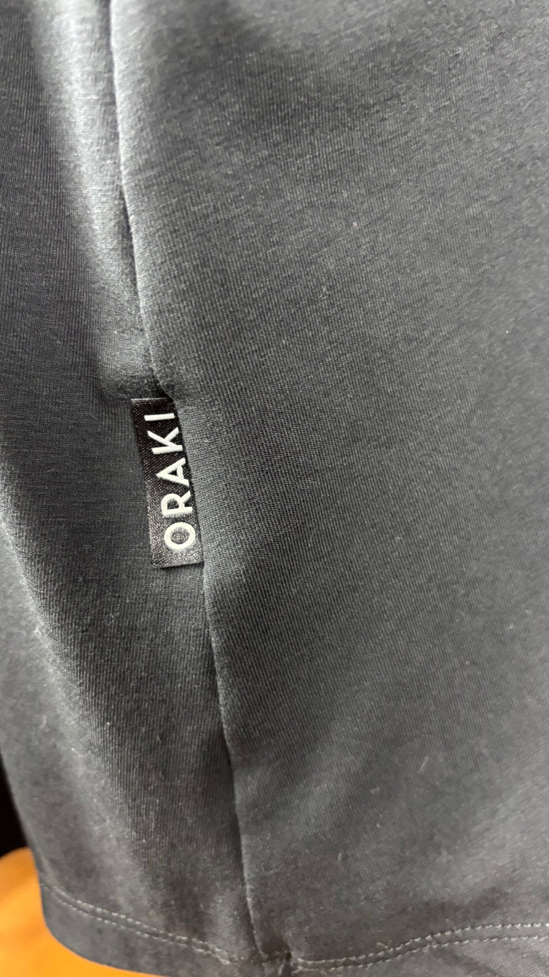 Camisole noire dos nageur et encolure ronde Oraki, taille 2X. Vue de la petite étiquette Oraki sur le côté de la camisole.