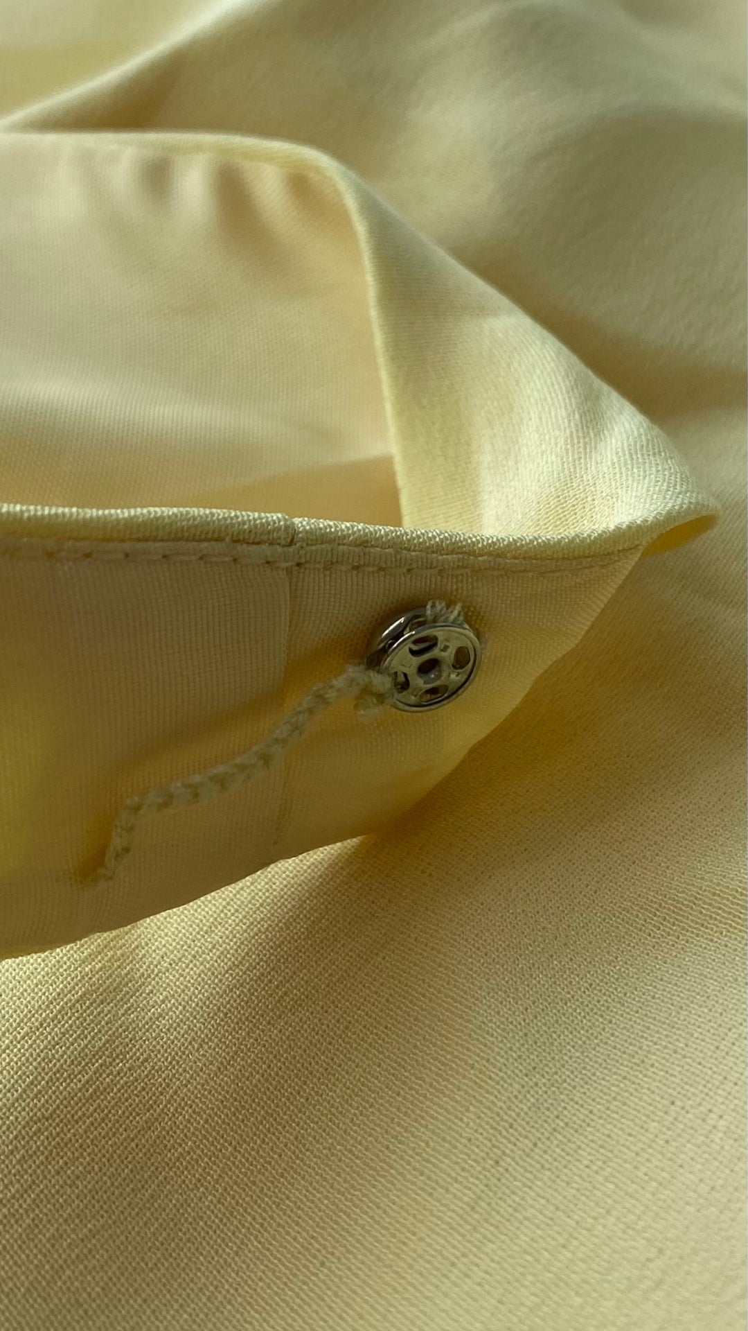 Camisole doublée en soie jaune doux Simon Chang, taille 16. Vue du bouton pression dans la bretelle pour maintenir la bretelle de soutien gorge en place.