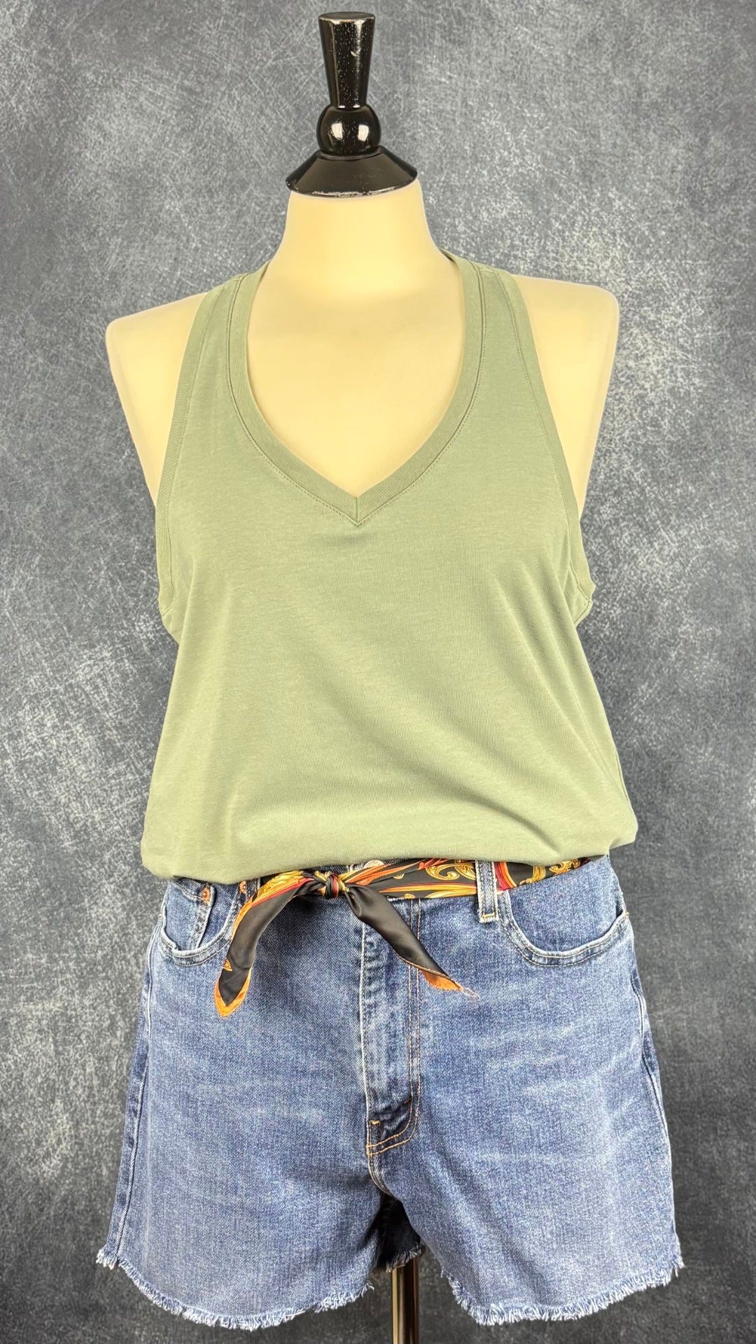 Camisole vert sauge à dos nageur et encolure en V, Oraki, taille xl. Vue de l'agencement avec le short en jeans Levi's et le foulard coloré carré.