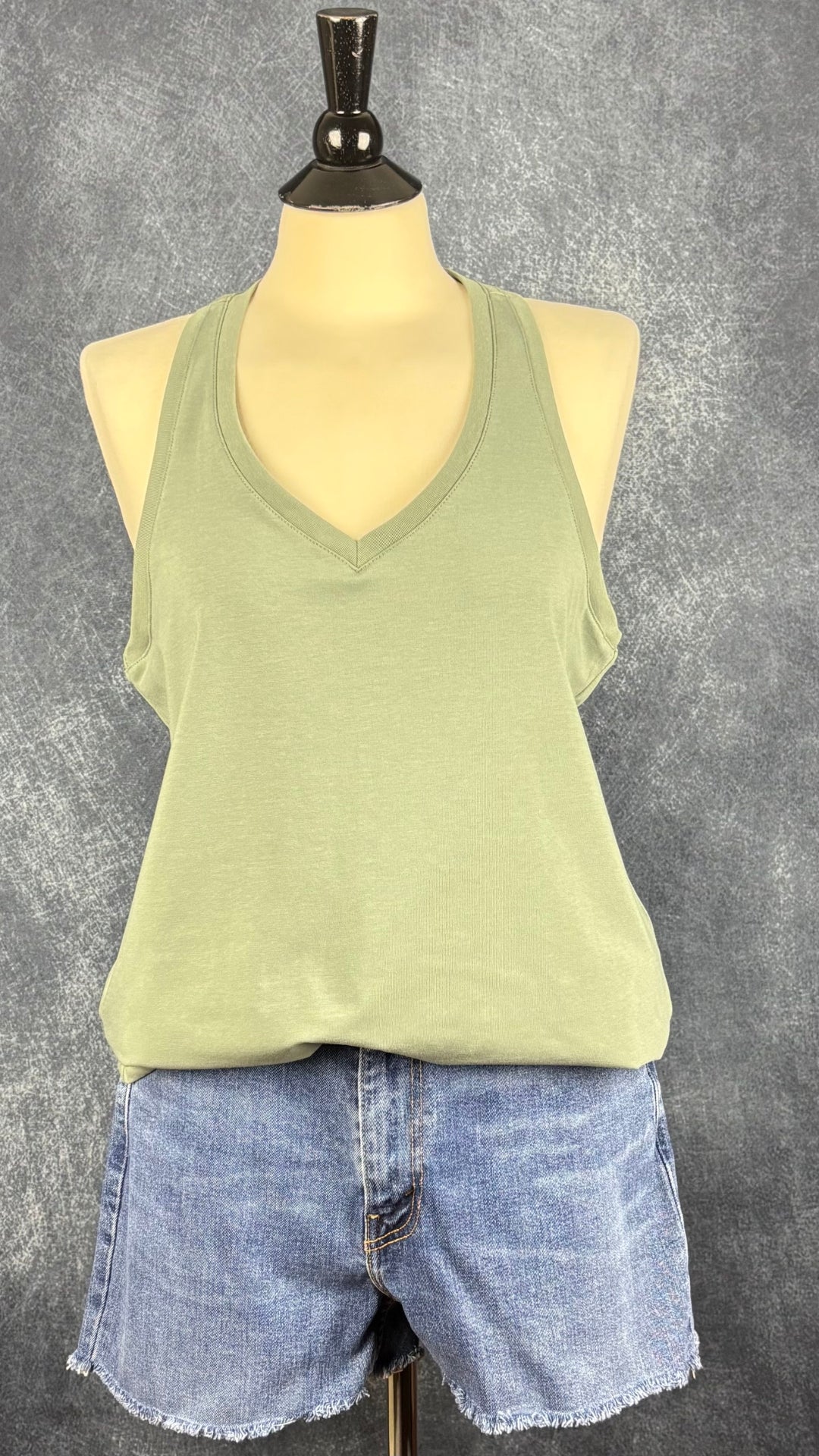 Camisole vert sauge à dos nageur et encolure en V, Oraki, taille xl. Vue de l'agencement avec le short en jeans Levi's.
