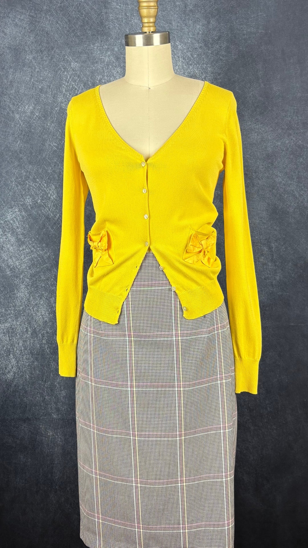 Cardigan en fin tricot jaune soleil avec petits boucles sur les poches, Tara Jarmon, taille small. Vue de l'agencement avec la jupe à carreaux colorés Tristan.