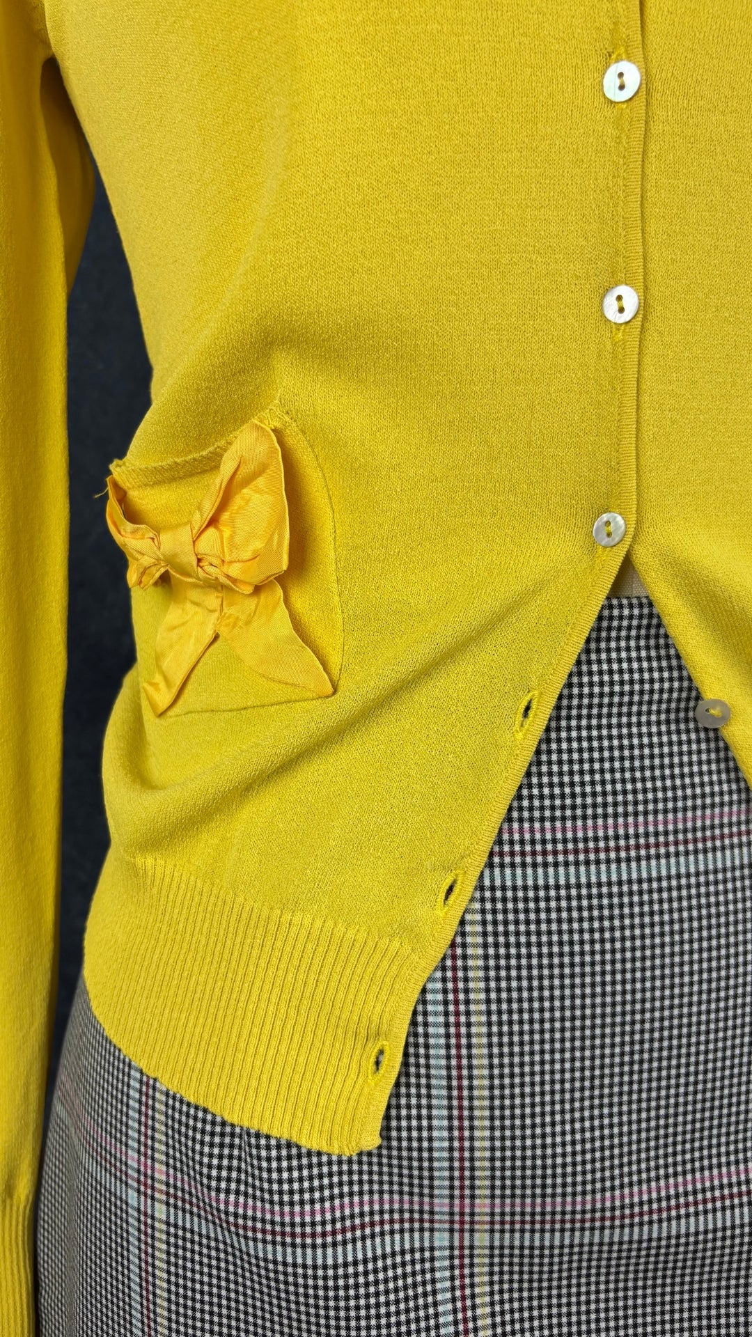 Cardigan en fin tricot jaune soleil avec petits boucles sur les poches, Tara Jarmon, taille small. Vue de près de l'agencement avec la jupe à carreaux Tristan.