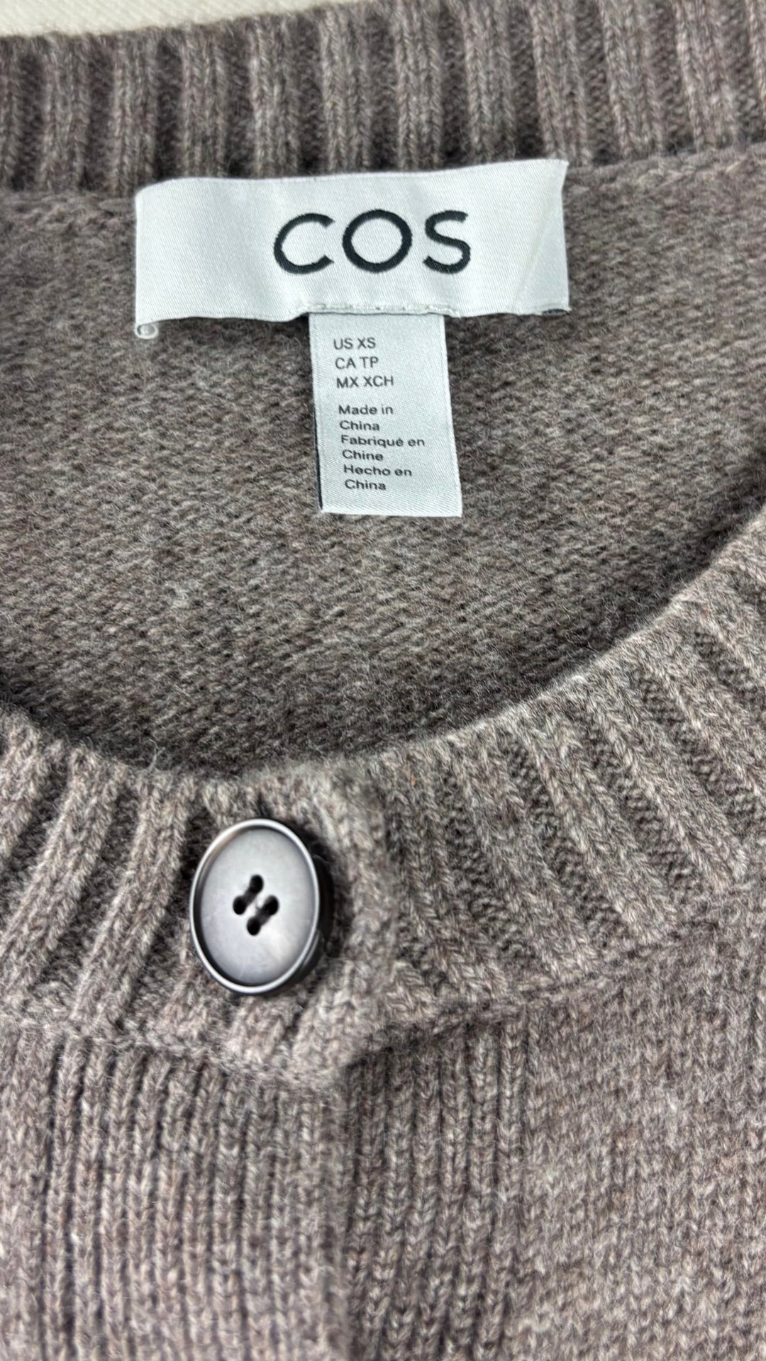 Cardigan taupe à manches courtes en laine Cos, taille xs. Vue de l'étiquette.