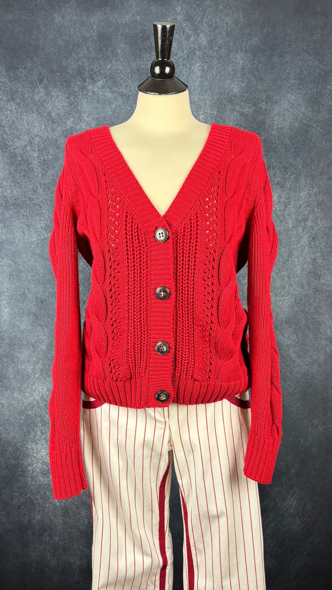 Cardigan rouge en tricot torsadé à col en V Esprit, taille medium. Vue de l'agencement avec le pantalon à rayures Andy The Anh.