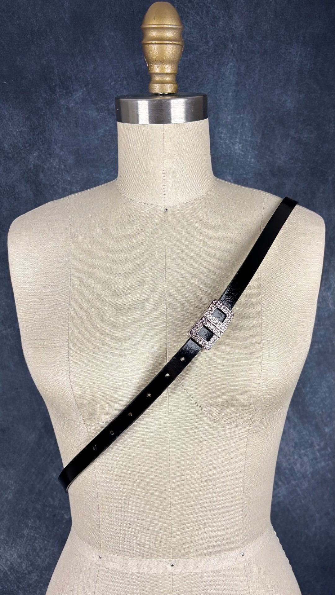 Ceinture fine en cuir vernis noir avec boucle sertie de cristaux étincelants Calvin Klein, taille xl. Vue de la ceinture en bandoulière sur le mannequin.