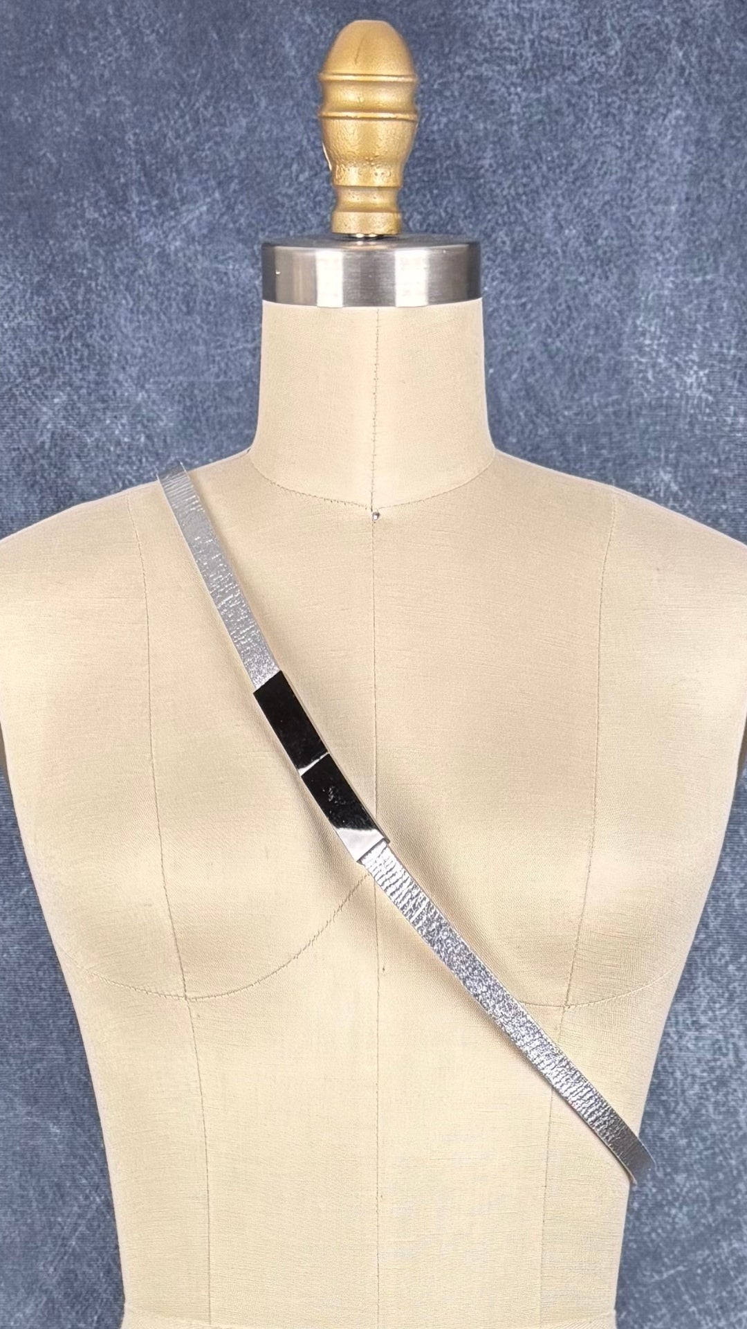 Ceinture en cuir véritable argent, fait au Canada Simons, taille unique. Vue en bandoulière sur le mannequin.