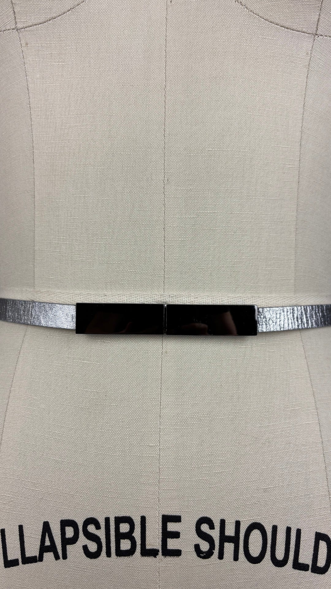 Ceinture en cuir véritable argent, fait au Canada Simons, taille unique. Vue de face, près de la boucle sur le mannequin.