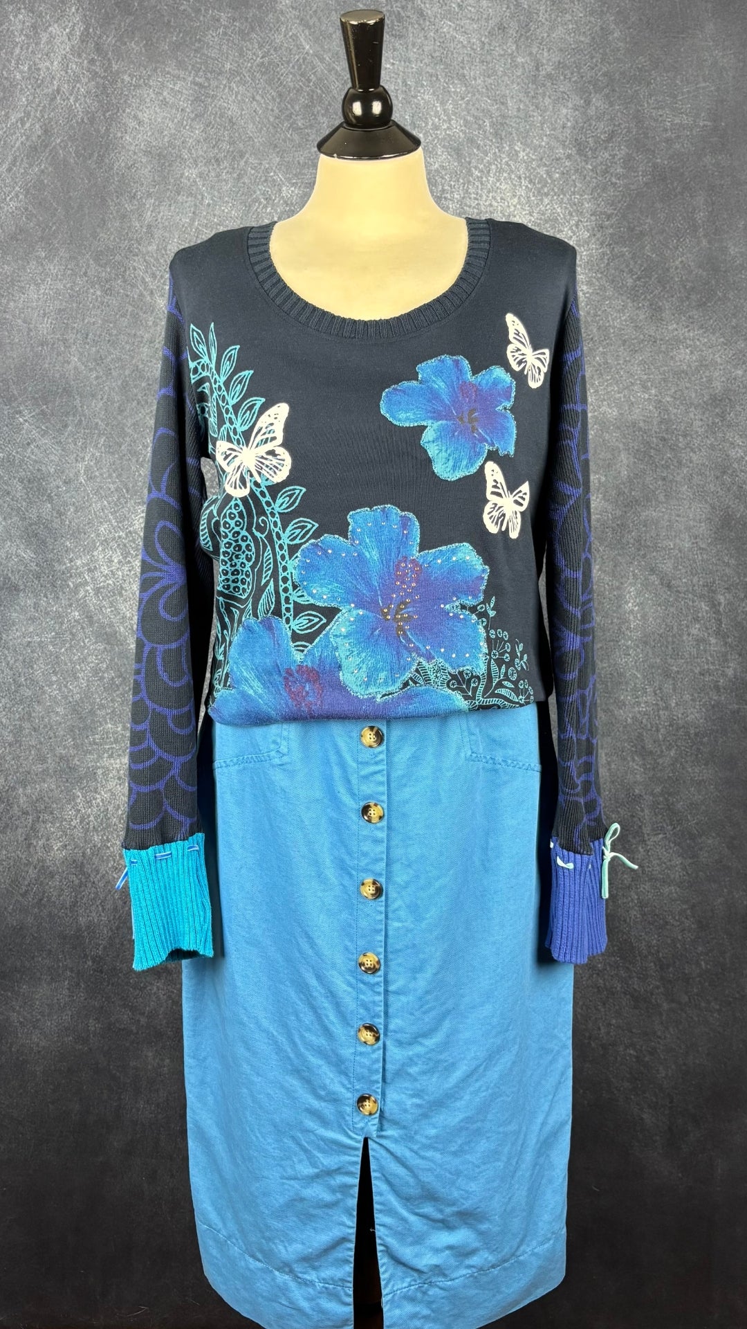 Chandail bi-matière en coton avec fleurs et papillons Desigual, taille xl (fait plus m/l). Vue de l'agencement avec la robe boutonnée bleue Cue.
