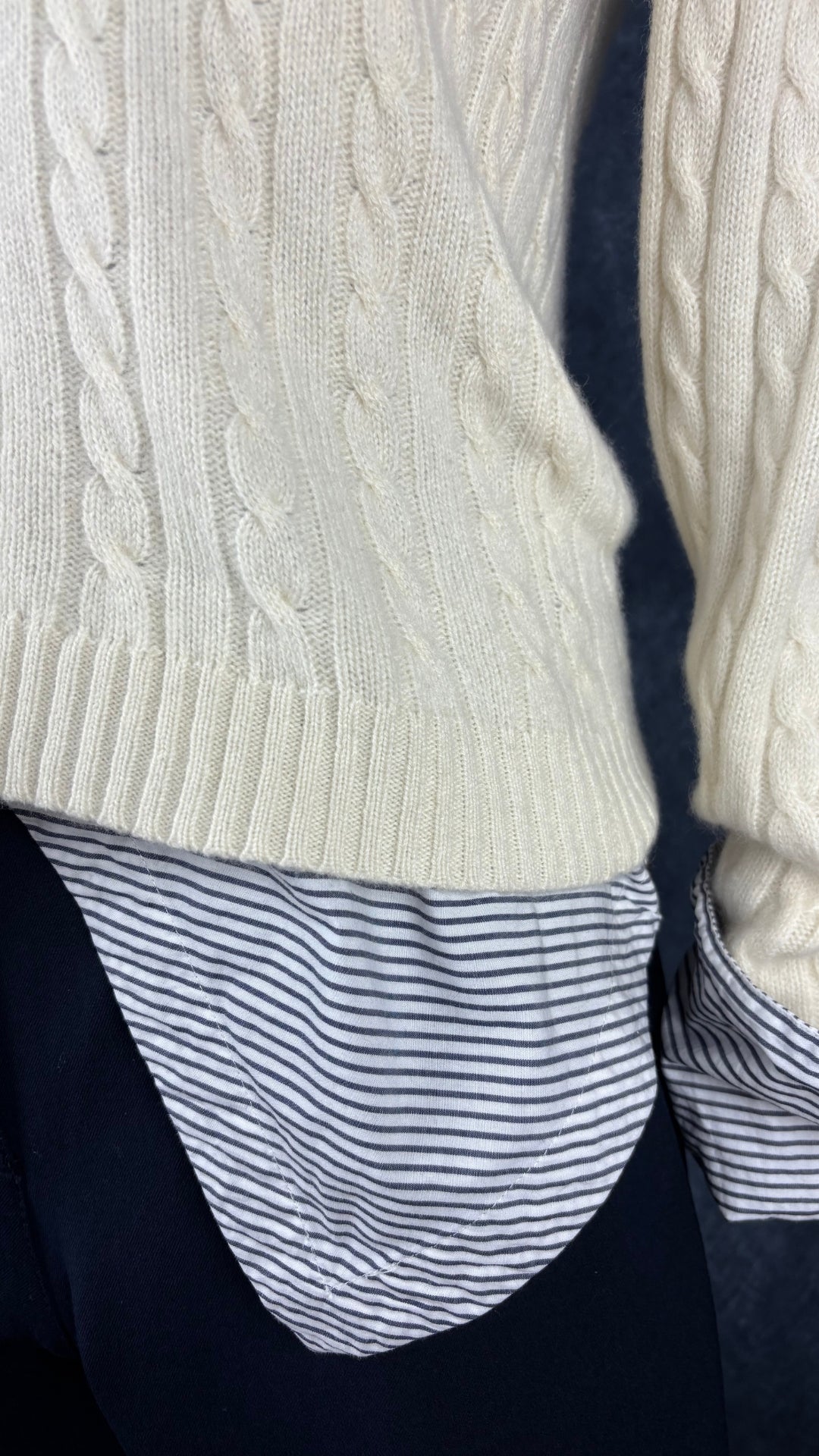 Chandail crème à col châle en cachemire Lauren Ralph Lauren, taille small. Vue de près de l'agencement avec la blouse à rayures Scotch & Soda et le pantalon marine Olsen.