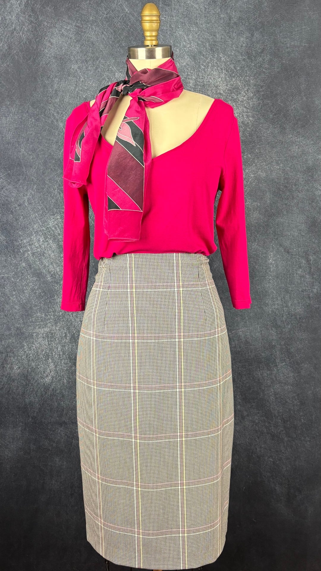 Chandail à col large en V rose fuchsia Isabelle Elie Boutique, taille estimée à s/m. Vue de l'agencement avec le foulard Cléo et la jupe à carreaux colorés Tristan.