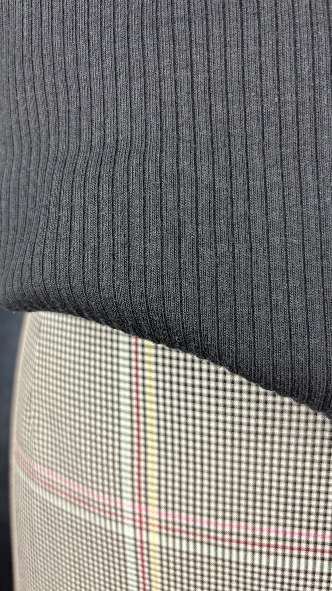 Chandail côtelé charcoal qui tire sur le marine, à manches trompettes, Mas Montréal, taille small. Vue de l'agencement avec la jupe à carreaux Tristan, de près.