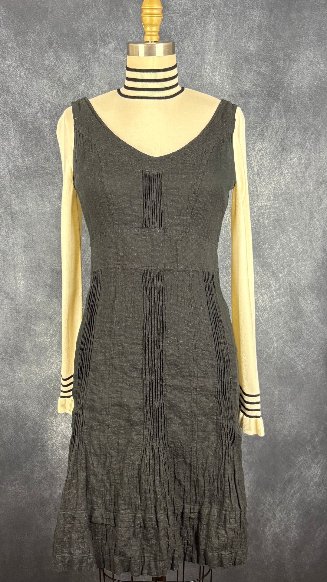 Chandail crème à col montant à ourlets à rayures noires et argentées Tristan, taille small. Vue de l'agencement avec la robe Luisa Cerano noire étincelante.