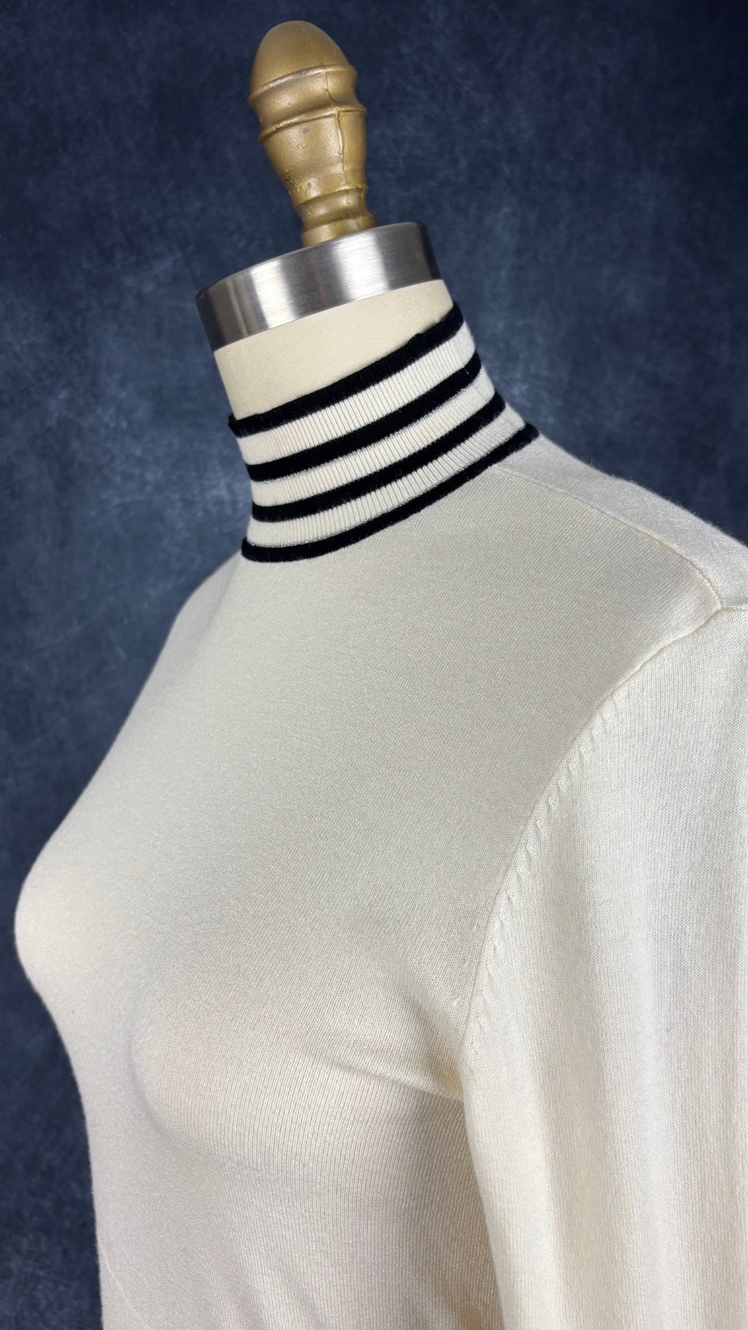 Chandail crème à col montant à ourlets à rayures noires et argentées Tristan, taille small. Vue de l'encolure.