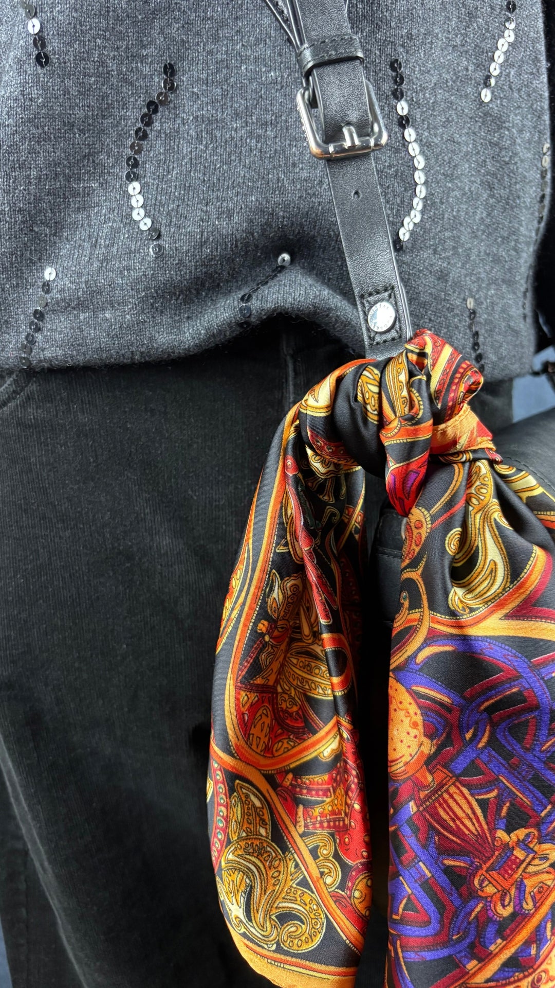 Chandail en fin tricot charcoal en soie et cachemire agrémenté de sequins, Jax, taille estimée à medium. Vue de l'agencement avec le pantalon en velours côtelé noir, le foulard coloré et le sac Rudsak, de près.
