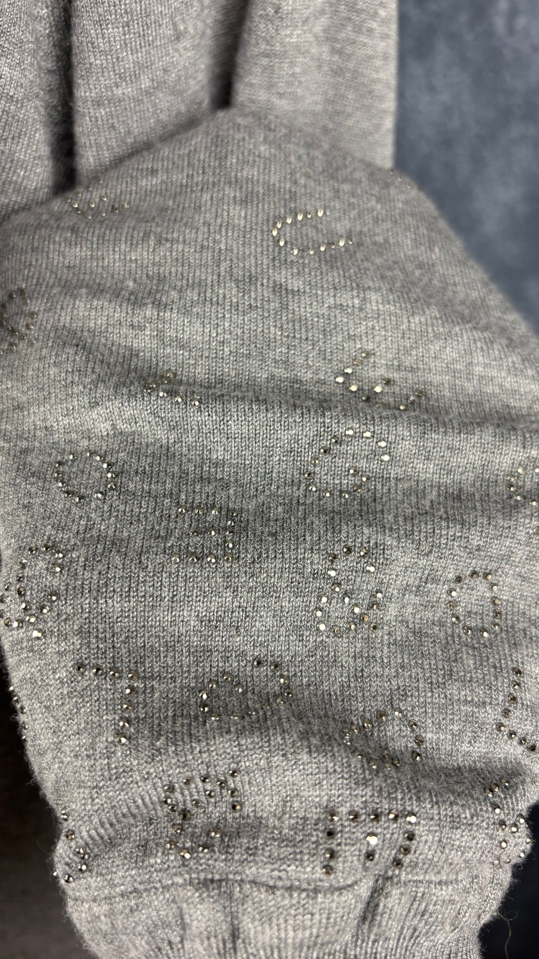 Chandail en fin tricot gris chiné avec insertions de cristaux en forme de lettres de l'alphabet au bas des manches Leo & Ugo, taille 4 (large). Vue de près du détail des manches.