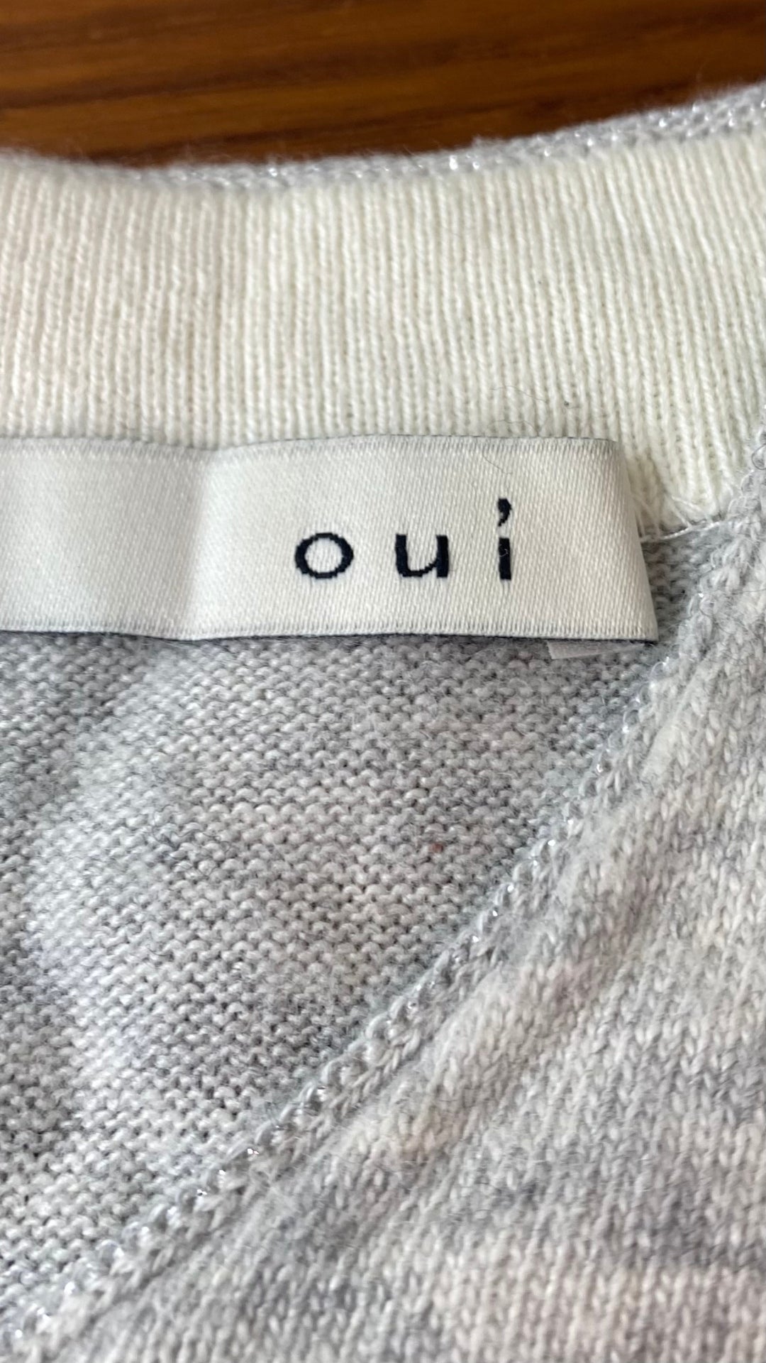Chandail long en tricot doux gris beige Oui, taille 10 (environ medium). Vue de l'étiquette de marque.
