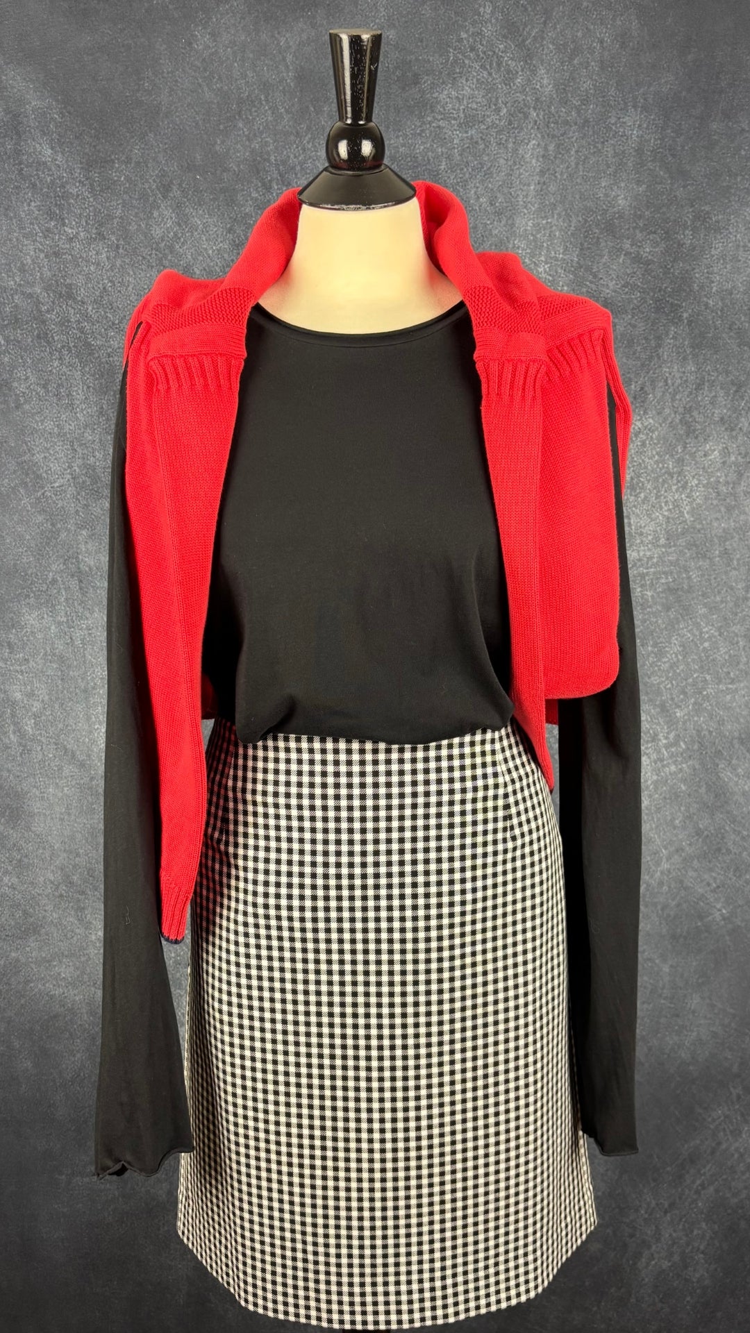 Chandail noir de base à manches longues Filippa K, taille l (xl). Vue de l'agencement avec la jupe à carreaux vichy et le tricot rouge Joules.