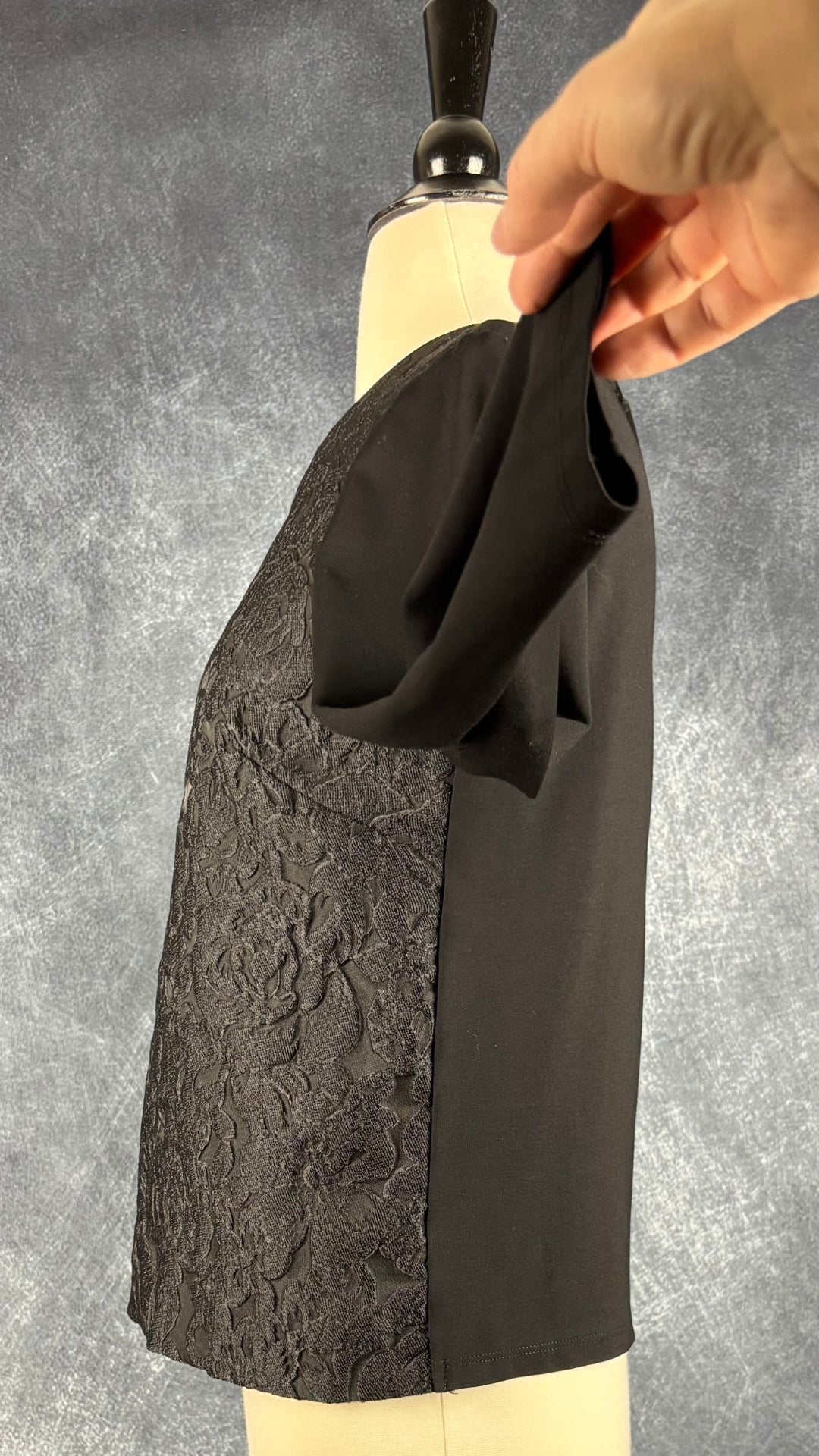 Chandail noir à devant floral texturé Weekend MaxMara, taille estimée à small. Vue de côté, manche relevée.