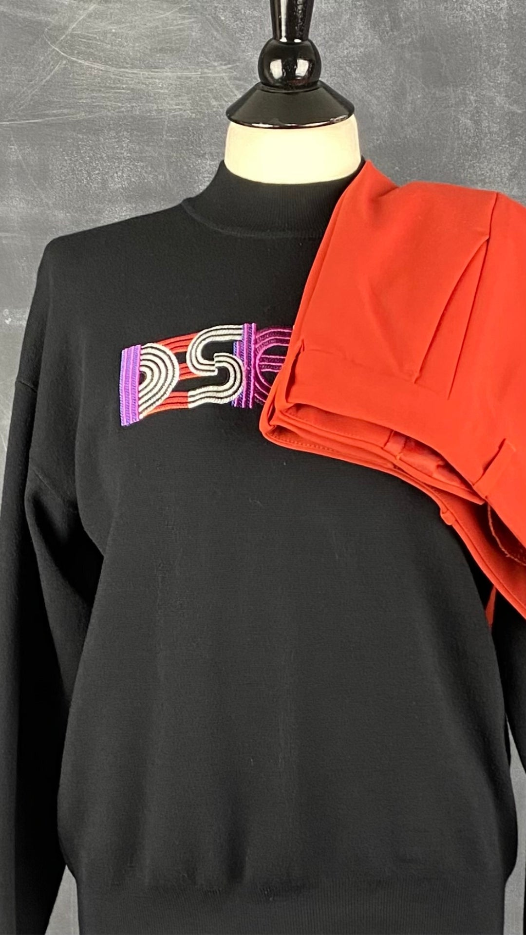 Chandail en tricot léger noir avec broderie Desigual, taille small. Vue de l'agencement avec le pantalon orangé Club Monaco.