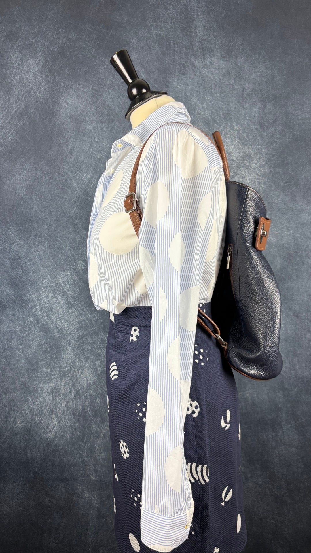 Chemisier blanc et bleu doux à rayures et cercles Brax, taille 38 (medium). Vue de l'agencement avec la jupe à motifs de ballons et le sac à dos en cuir Vera Pelle.
