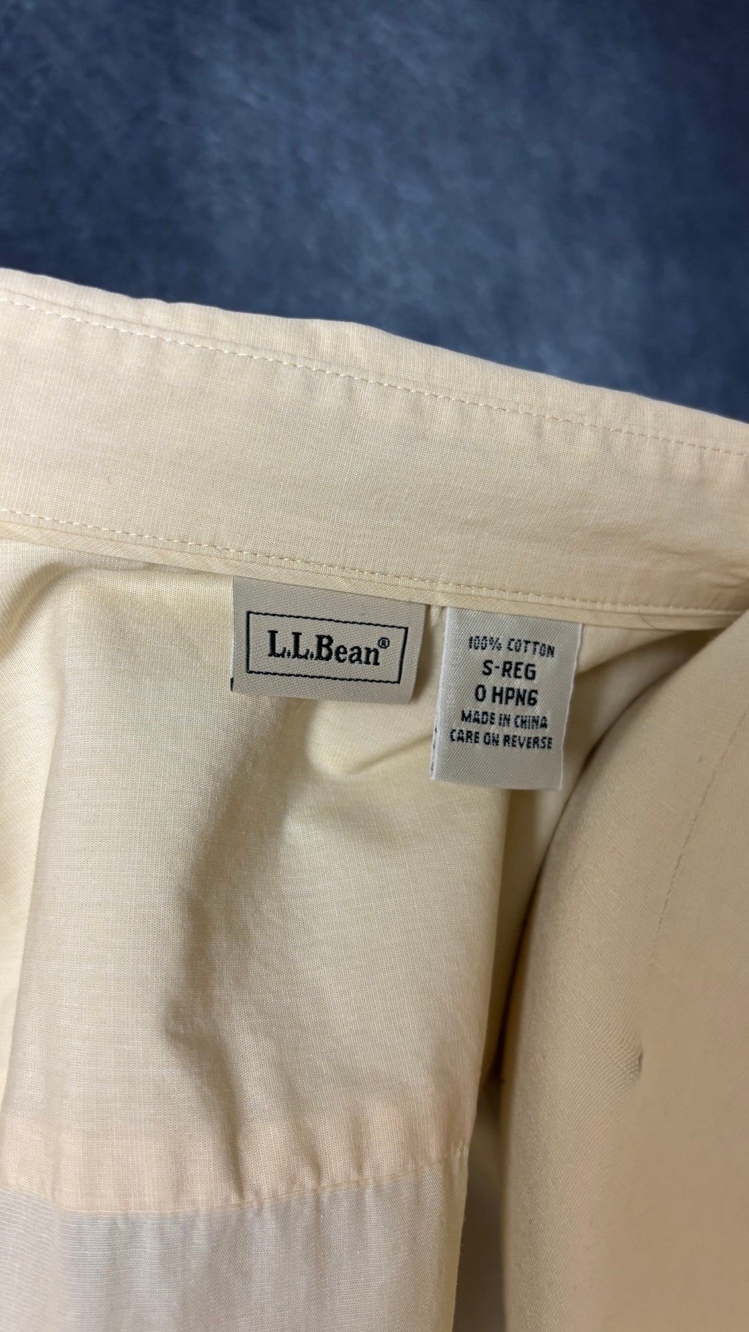 Chemisier en coton couleur crème au beurre avec frisons de chaque côté de la boutonnière, L.L.Bean, taille small. Vue de l'étiquette.