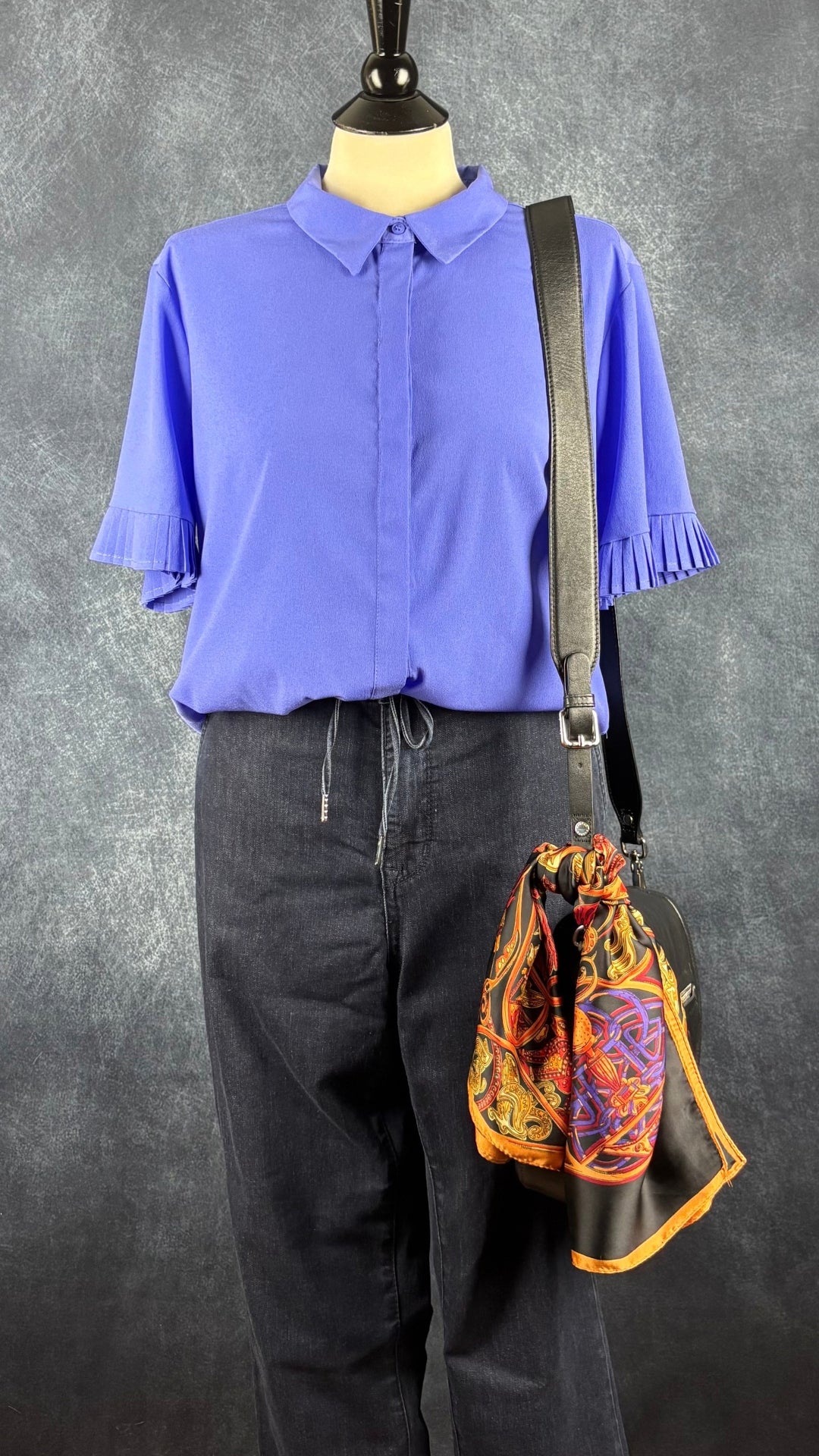 Chemisier lavande avec ourlets des manches plissés, French Connection, taille medium. Vue de l'agencement avec le jeans confortable Tristan, le foulard coloré et le sac à main Rudsak.