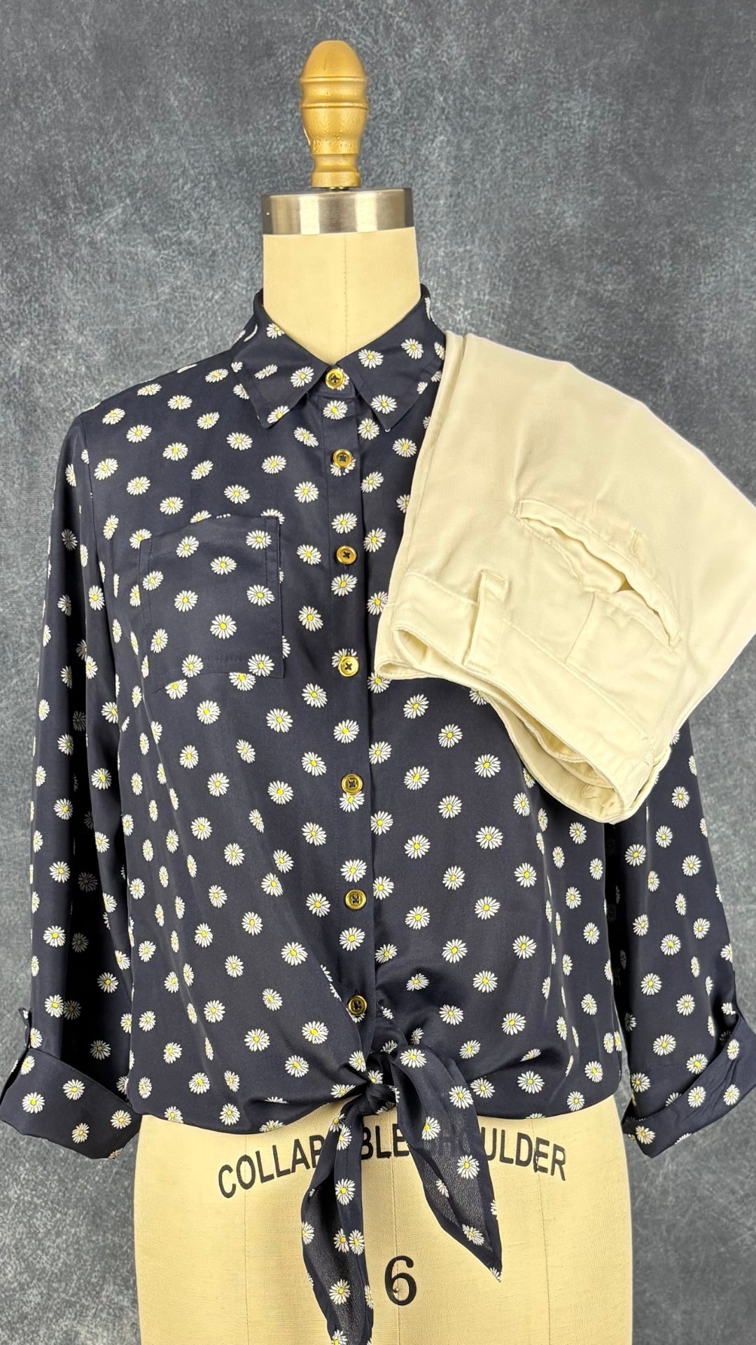 Chemisier à motifs de marguerites à boutons dorés Jones New York Signature, taille PP (small/medium pour femmes de moins de 5'4''). Vue de l'agencement avec le pantalon crème en Lyocell de Anthropologie.